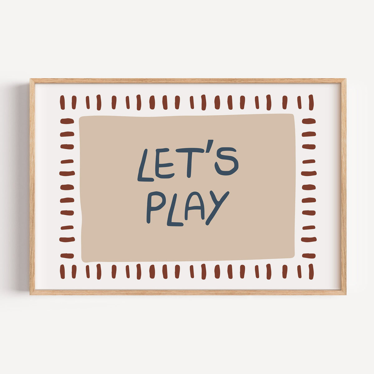 Landscape lets play typography nursery print in a light oak frame on a plain white wall