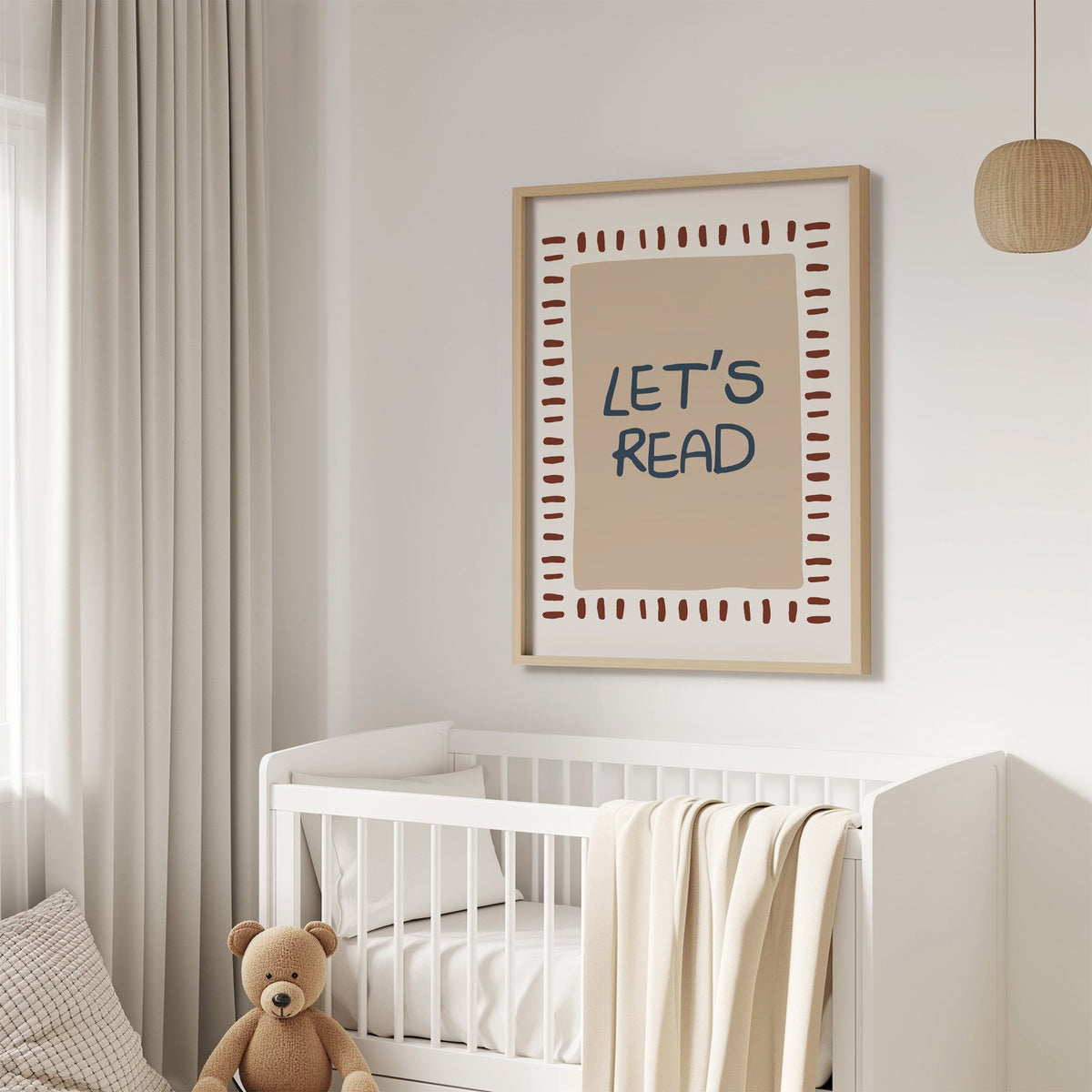 Lets read typography nursery print in an oak frame above a white crib with a teddy bear