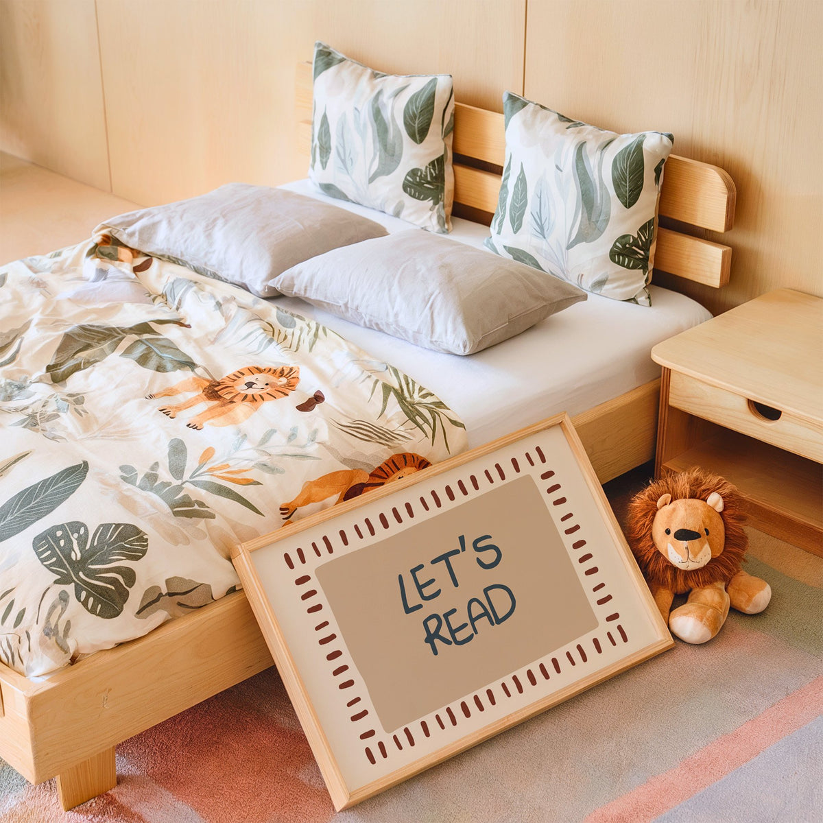 Landscape lets read typography nursery print in an oak frame leaning on a kids bed by a lion plush