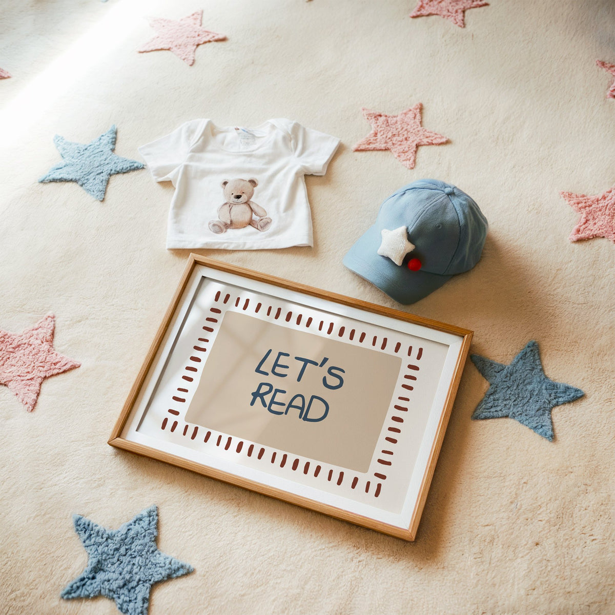 Landscape lets read typography nursery print in a matted oak frame on a star rug with a baby tee
