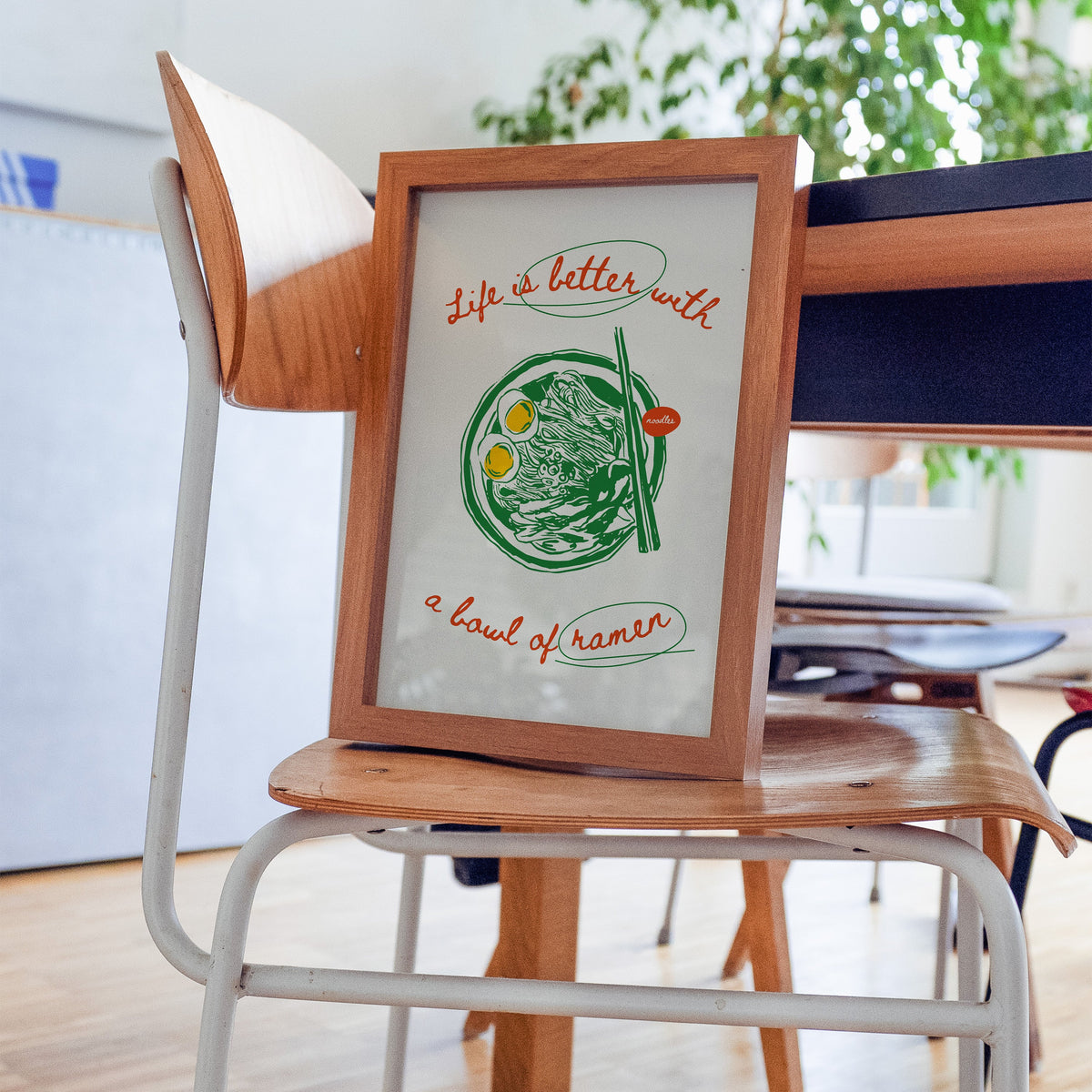 Life Is Better With Ramen print in a walnut frame on a bentwood chair
