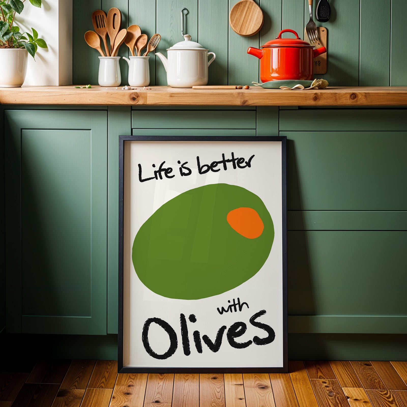 Life is better with olives print in a black frame against sage green kitchen cabinets