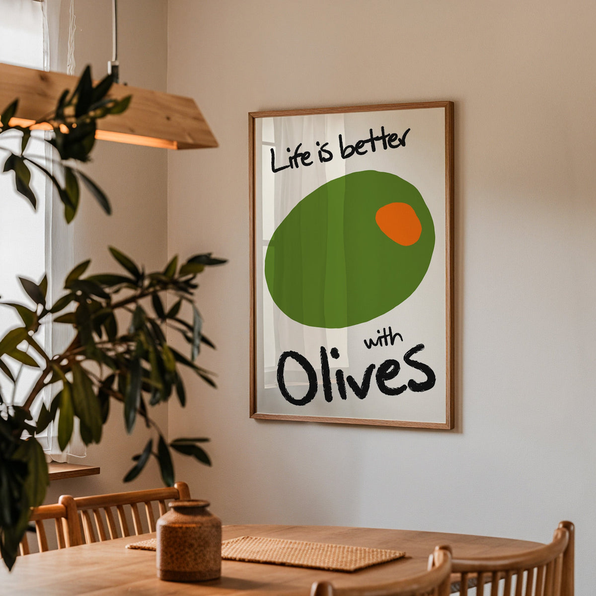Life is better with olives print in a walnut frame above a table beside an olive tree
