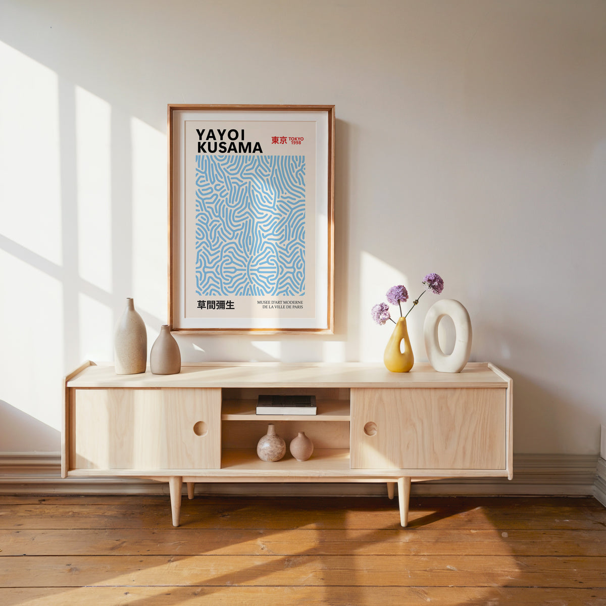 Yayoi Kusama inspired light blue squiggle pattern print above a pale wood console