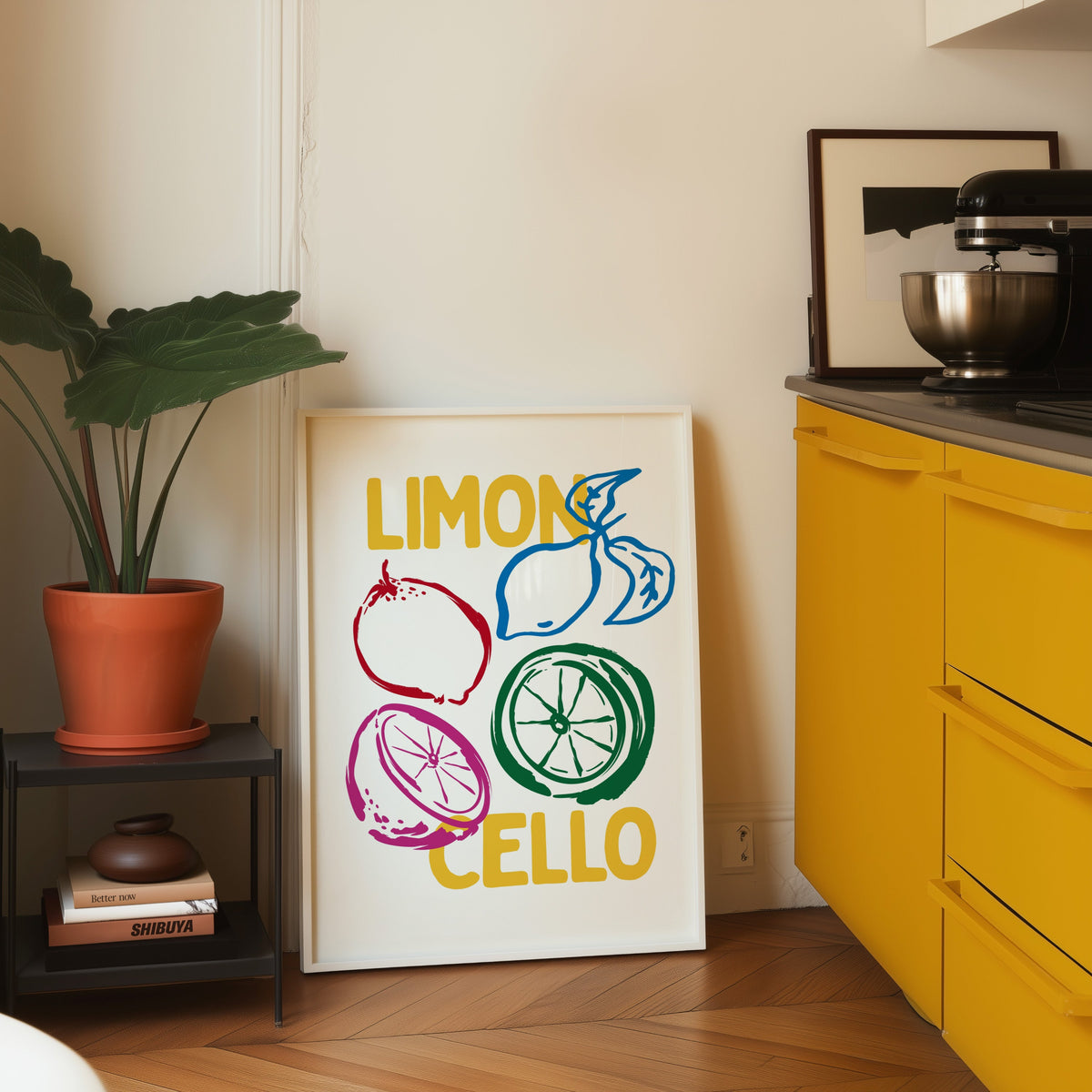 Limoncello lemon sketch print in a white frame leaning on parquet beside a bright yellow kitchen