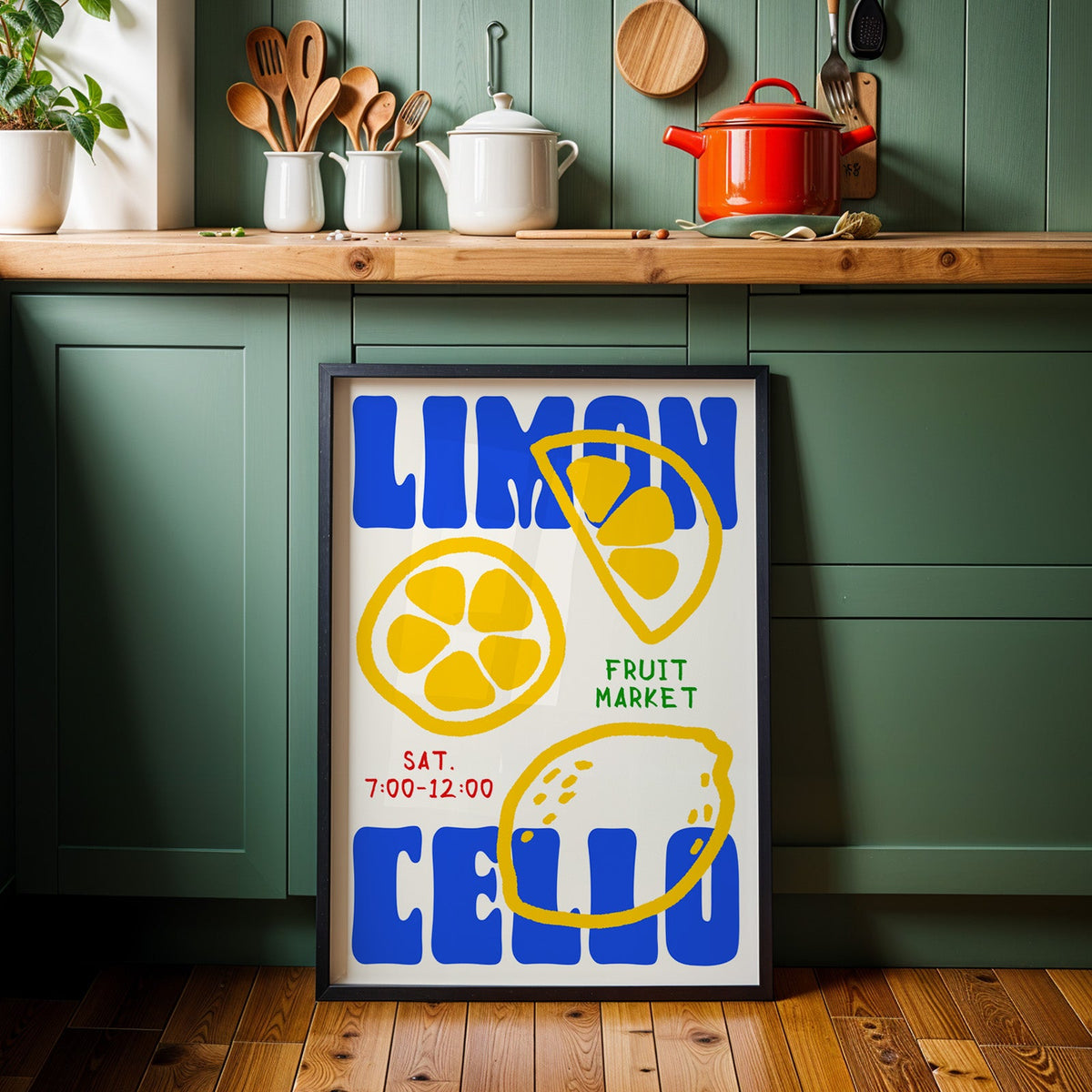 Limoncello lemon print in a black frame against sage green kitchen cabinets