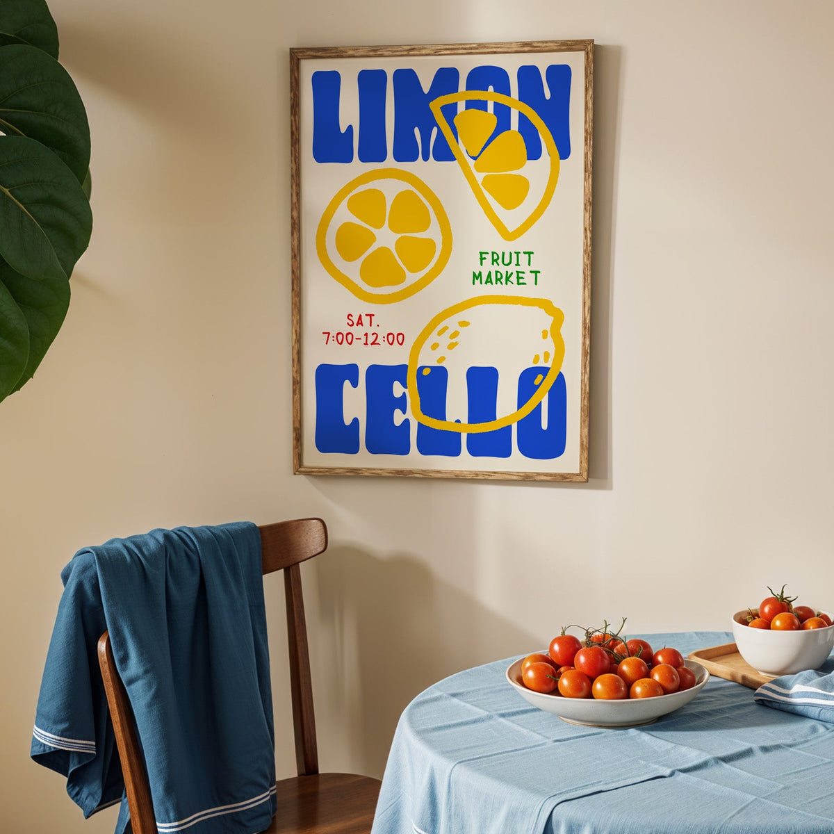Limoncello lemon print in an oak frame above a blue linen table with ripe tomatoes
