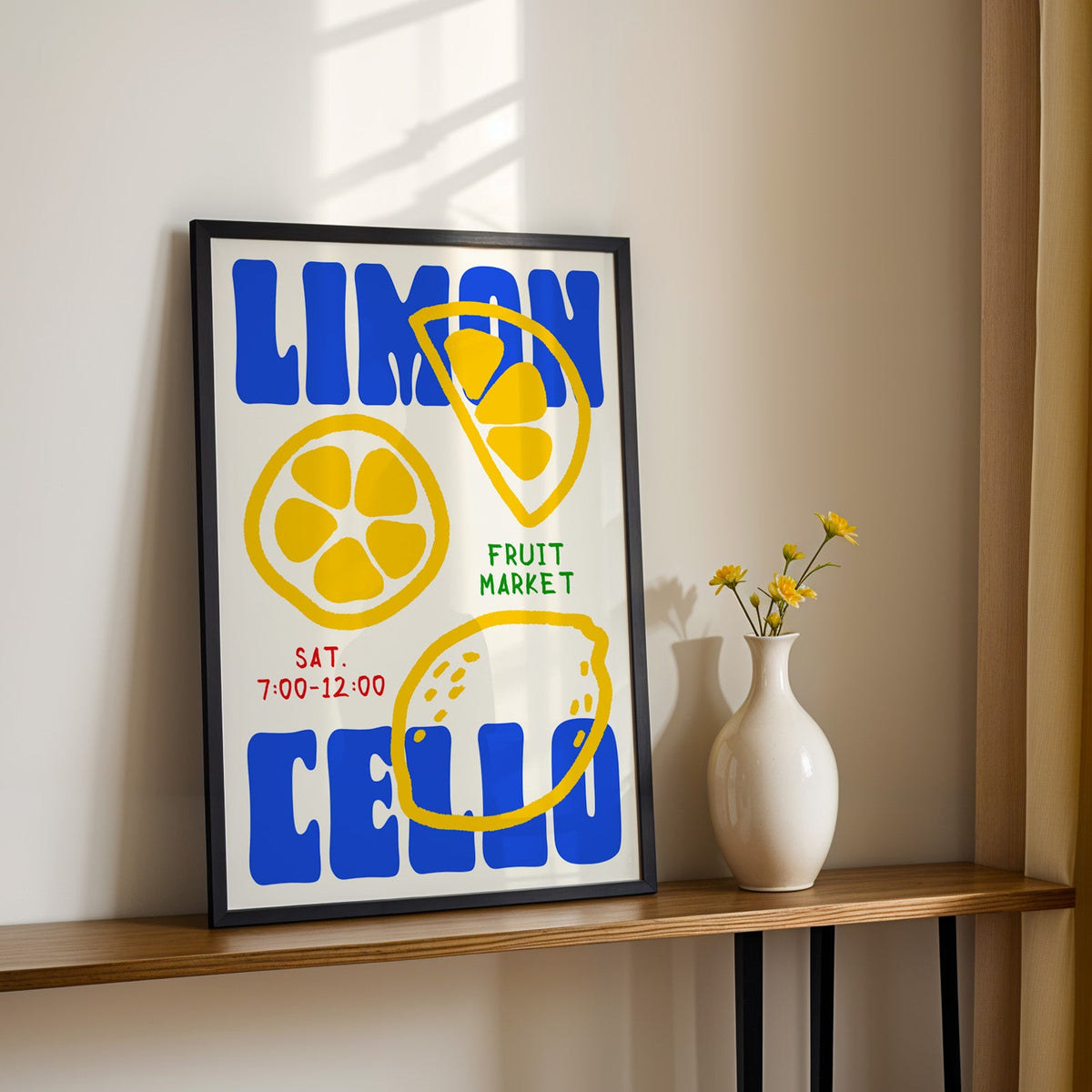 Limoncello lemon print in a black frame on a console table with yellow daisies