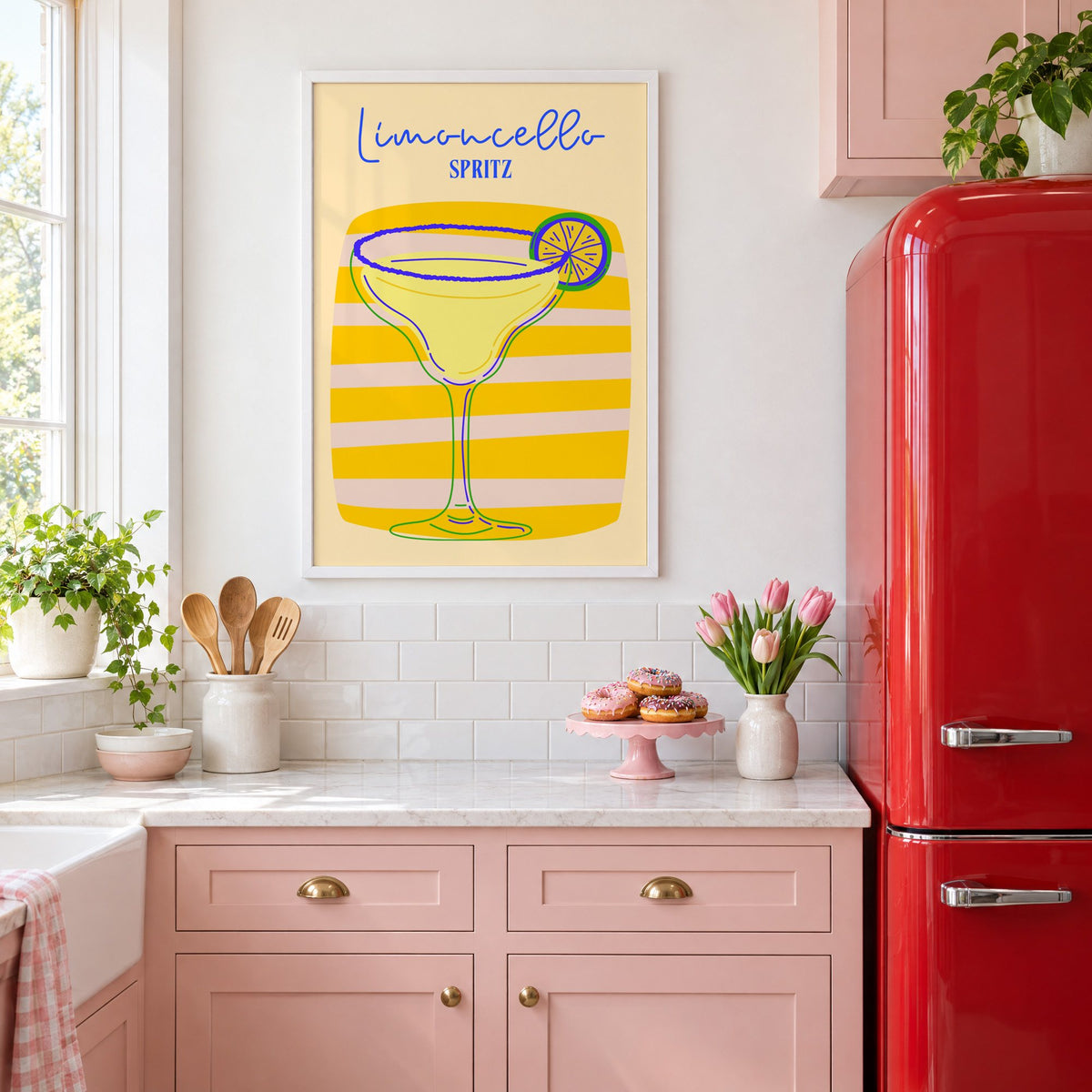 Limoncello Spritz yellow stripe print in a white frame in a pink kitchen beside a red retro fridge