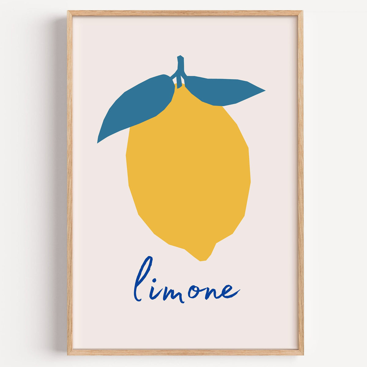 limone yellow cut-paper lemon print in a light oak frame on a plain white wall