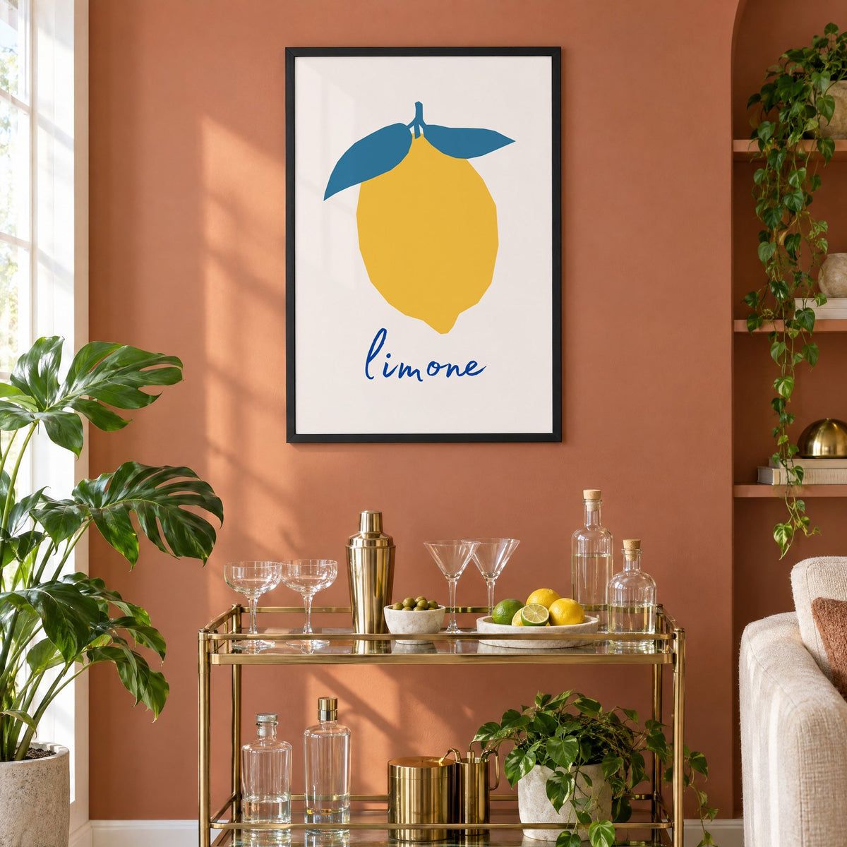 limone yellow cut-paper lemon print in a black frame on a terracotta wall above a brass bar cart with coupes and citrus
