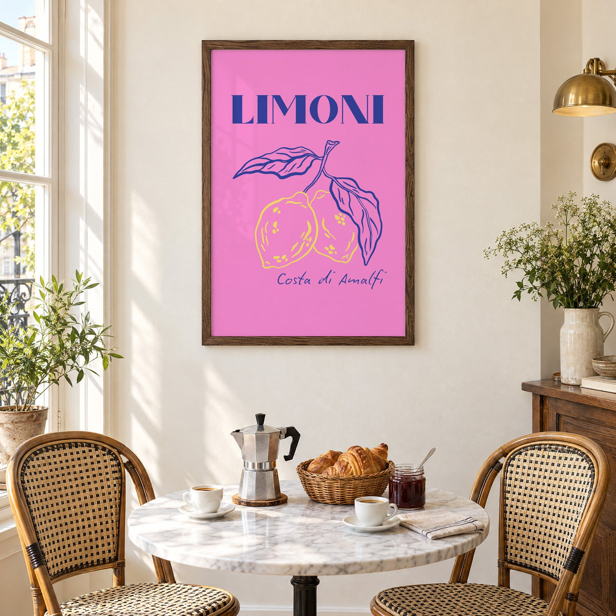 LIMONI Costa di Amalfi lemon branch print in a walnut frame above a marble bistro table with croissants and rattan chairs