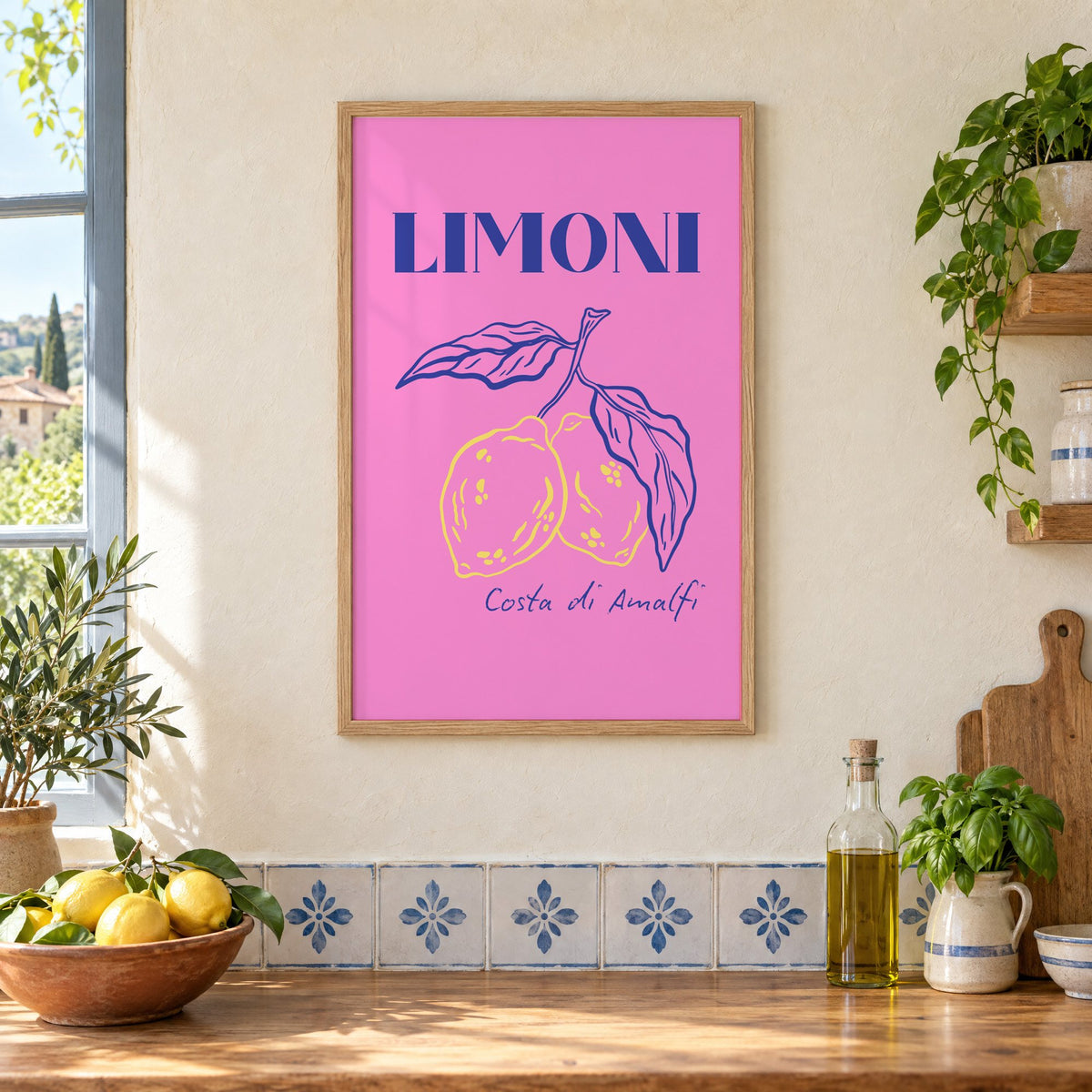 LIMONI Costa di Amalfi lemon branch print in an oak frame on a cream plaster wall above a worktop with a bowl of lemons and blue-and-white tiles