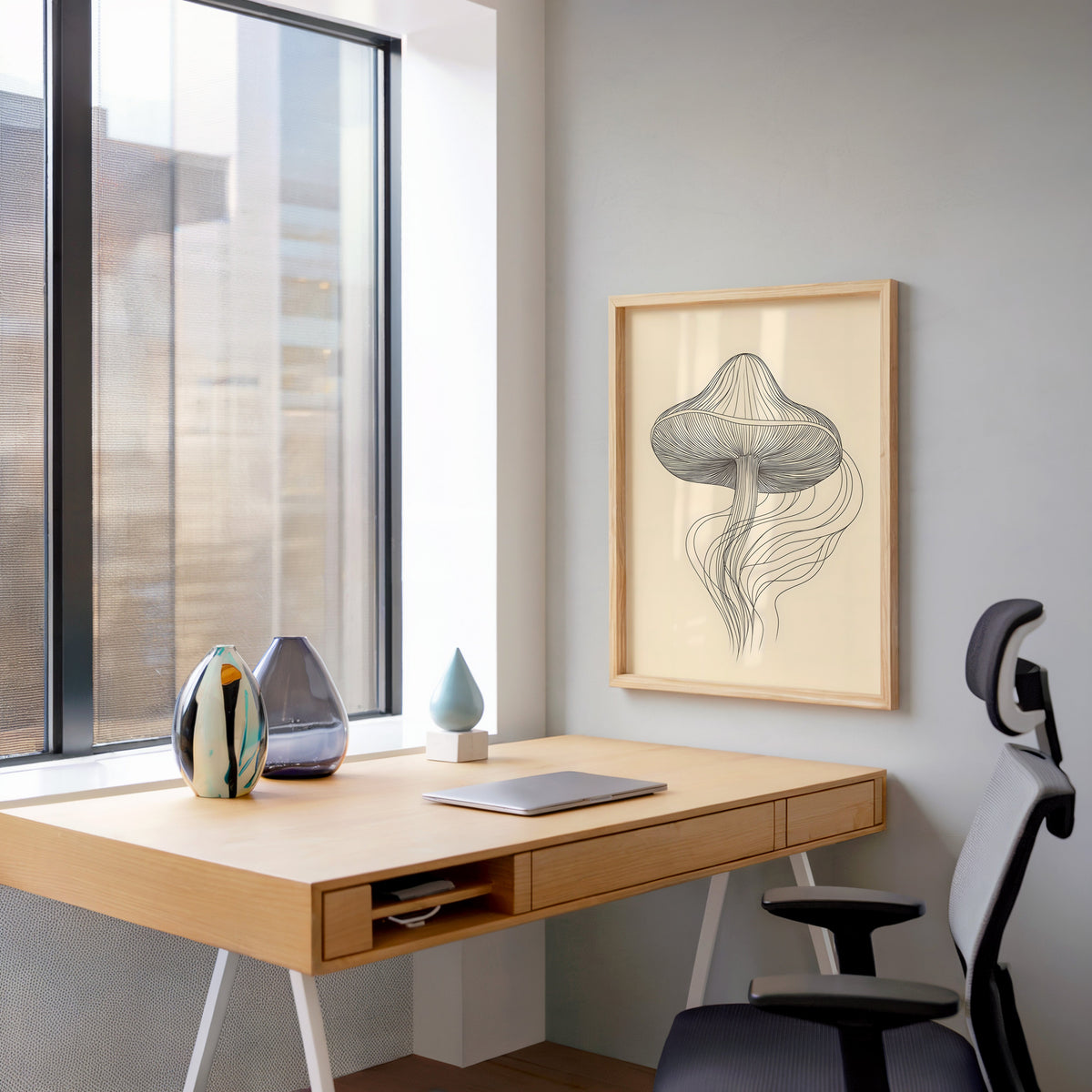 Line art mushroom with flowing lines print in a pale wood frame above a home office desk by a tall window