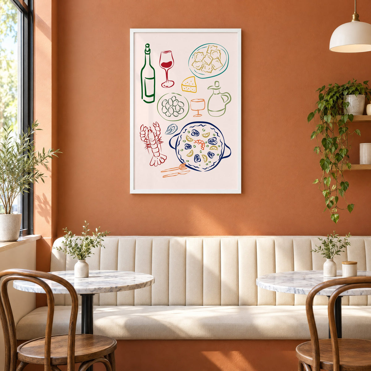Line art paella wine olives print in a white frame above a cream banquette on a terracotta cafe wall