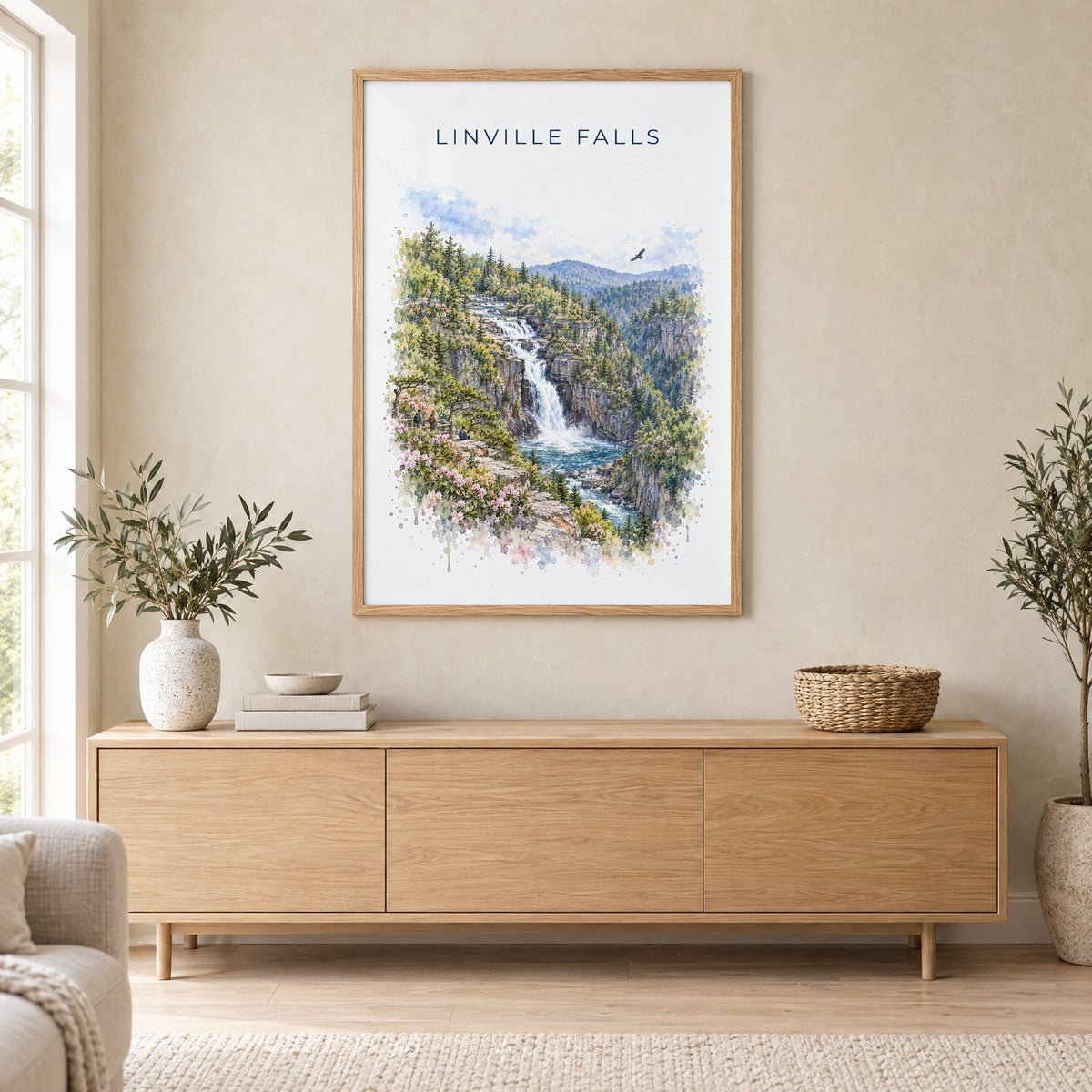 Linville Falls watercolor print in an oak frame above a light wood sideboard in a Scandinavian living room