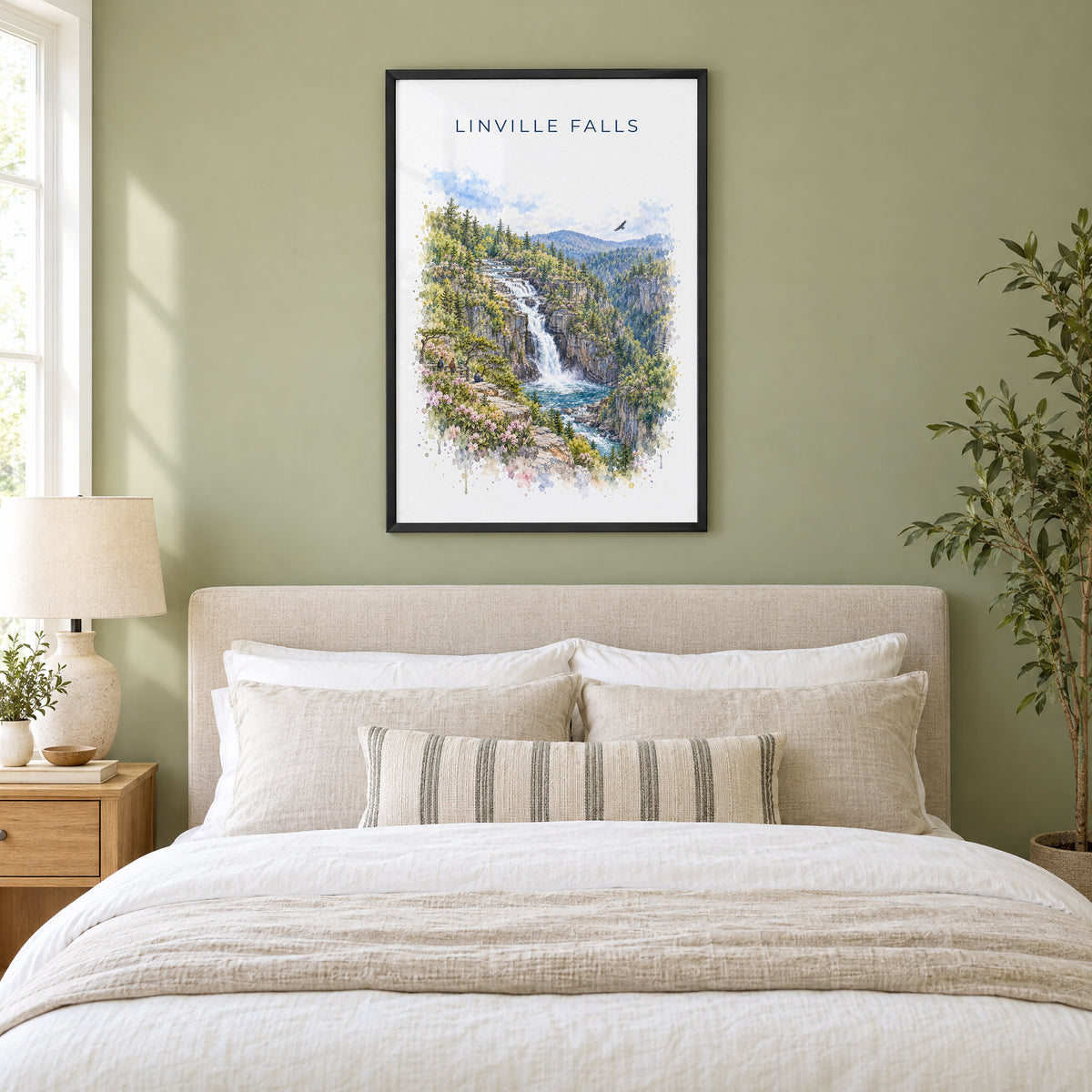 Linville Falls watercolor print in a black frame above an upholstered headboard in a sage green bedroom