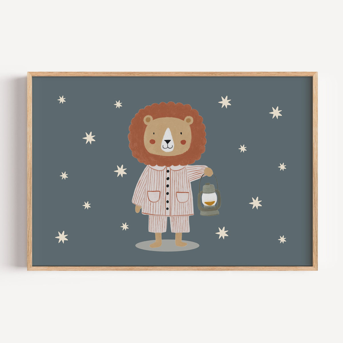 Landscape lion in pajamas with lantern nursery print in a light oak frame on a plain white wall