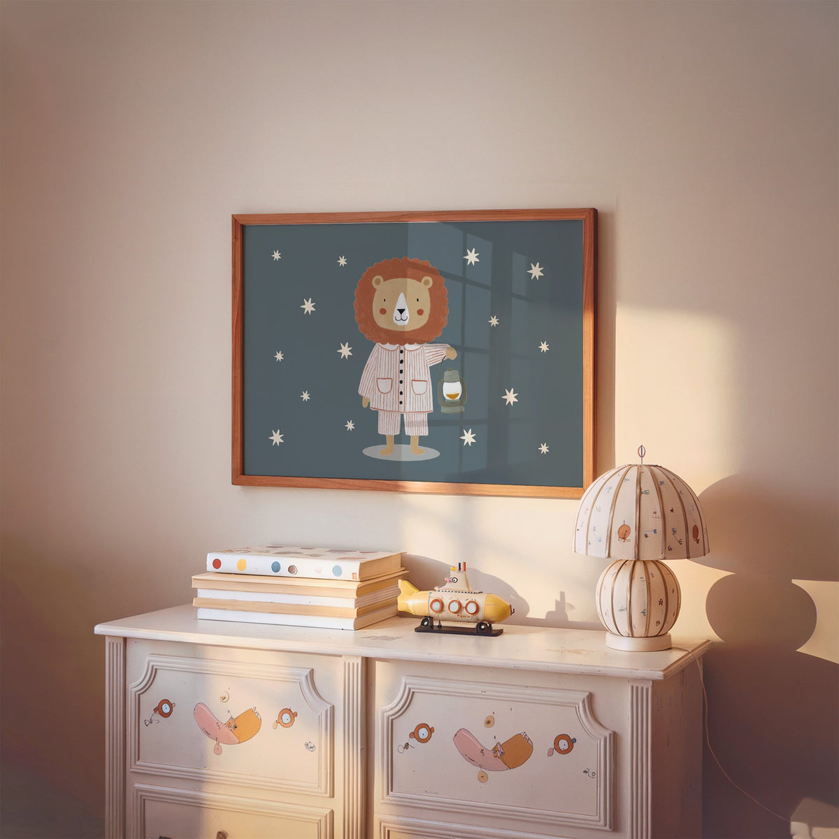 Landscape lion in pajamas with lantern nursery print in a cherry wood frame above a painted dresser and lamp