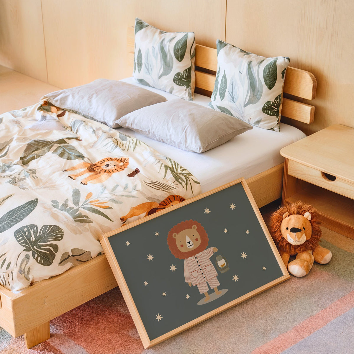 Landscape lion in pajamas with lantern nursery print in an oak frame leaning on a kids bed by a lion plush