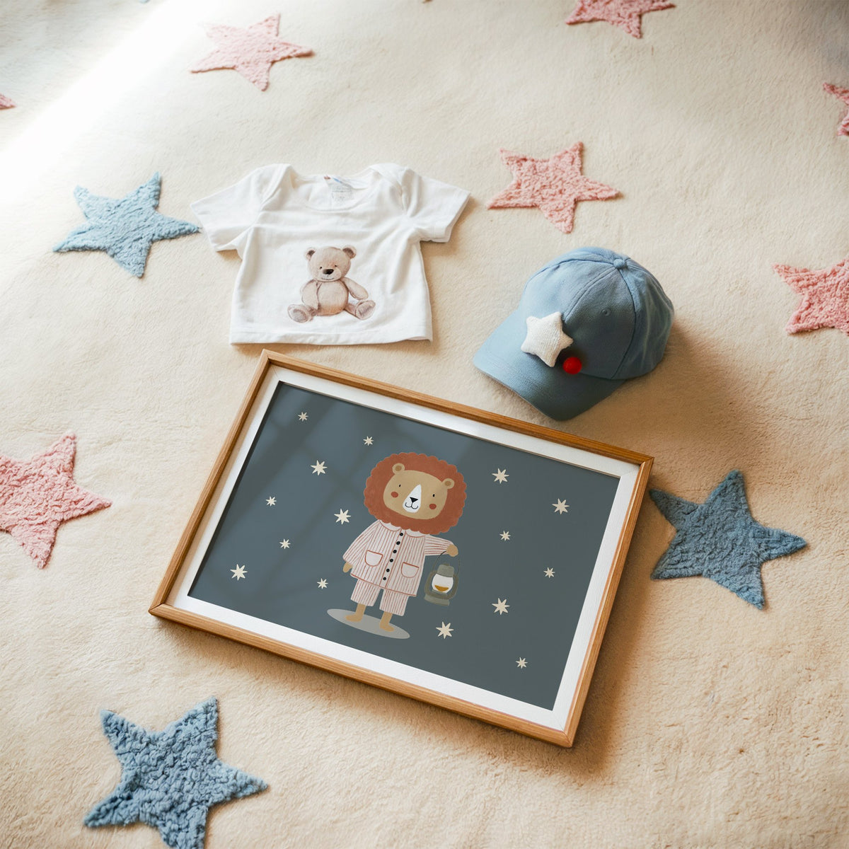 Landscape lion in pajamas with lantern nursery print in a matted oak frame on a star rug with a baby tee
