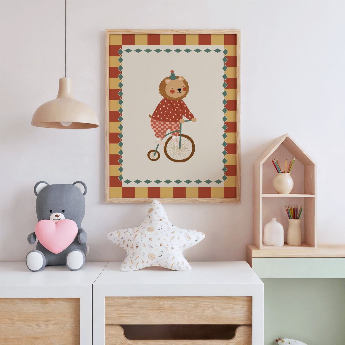 Lion penny-farthing circus nursery print in an oak frame above a white dresser with a star pillow and house shelf