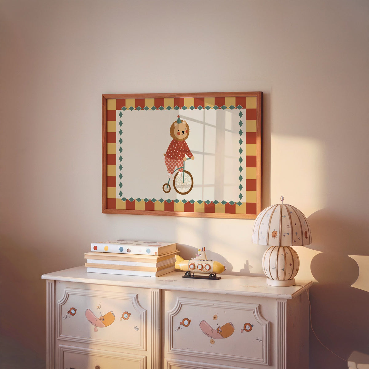 Landscape lion penny-farthing circus nursery print in a cherry wood frame above a painted dresser and lamp