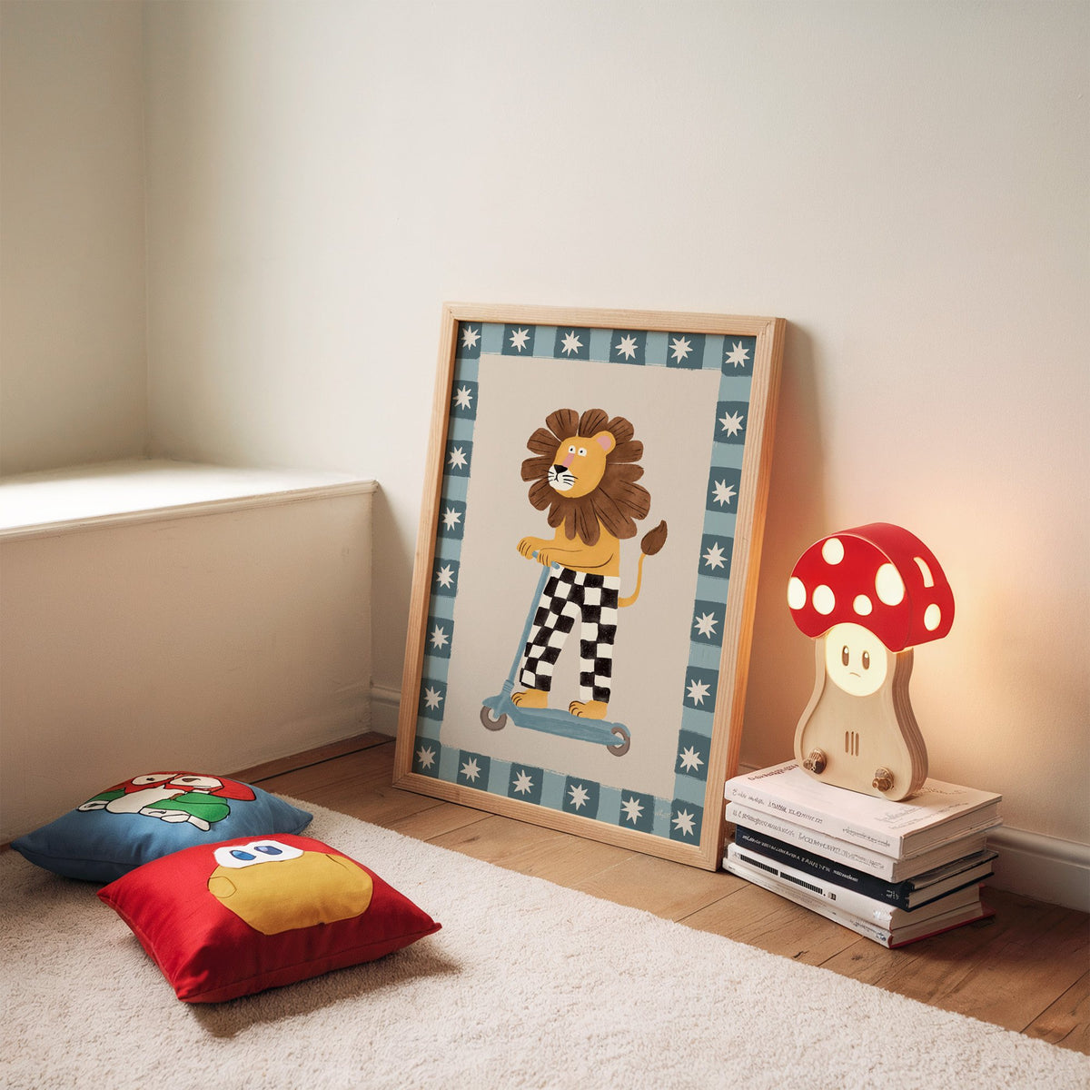Lion on scooter in checkered pants nursery print in an oak frame leaning on a rug beside a mushroom lamp and floor cushions