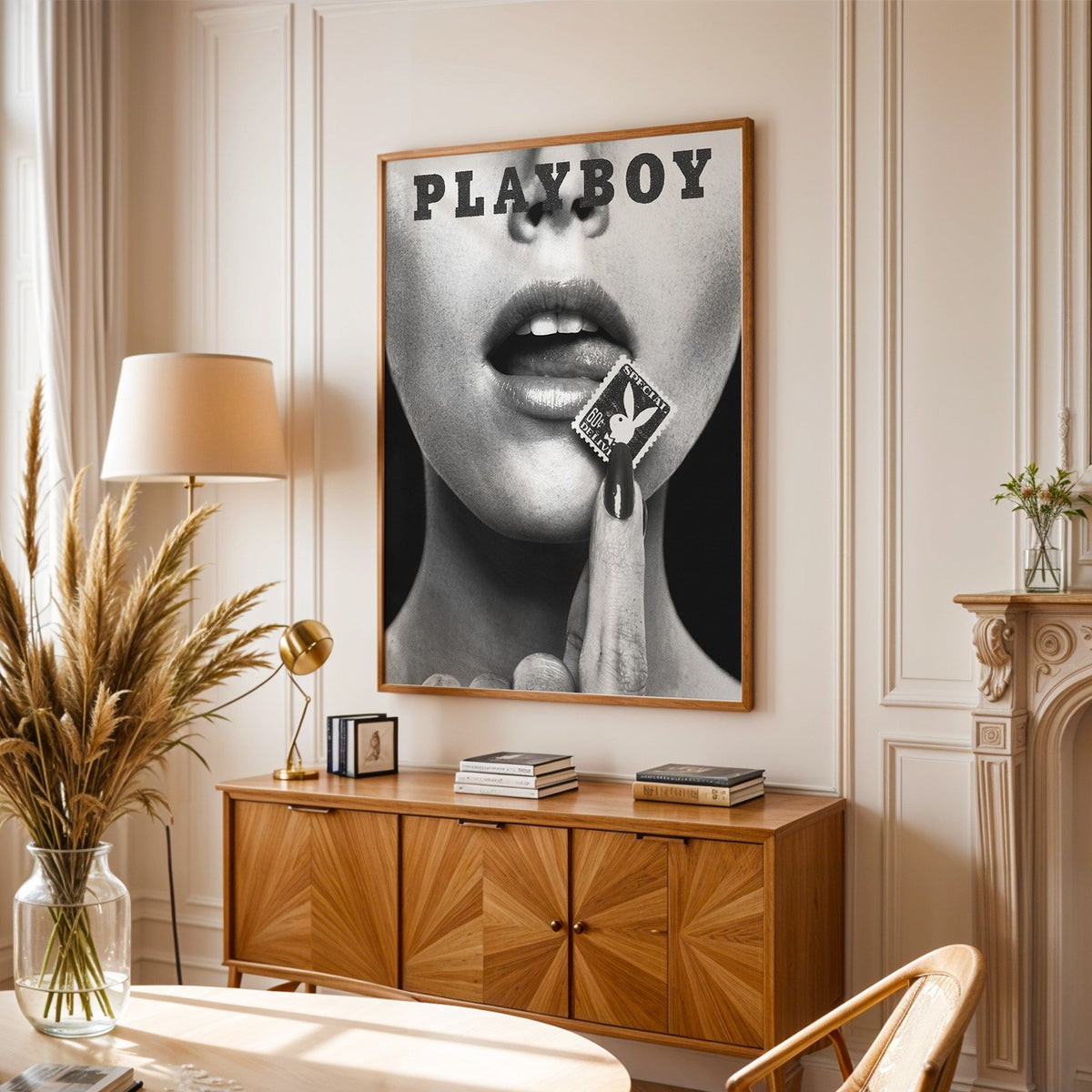 Glossy lips with postage stamp on black print in an oak frame above a sunburst wood sideboard with pampas grass