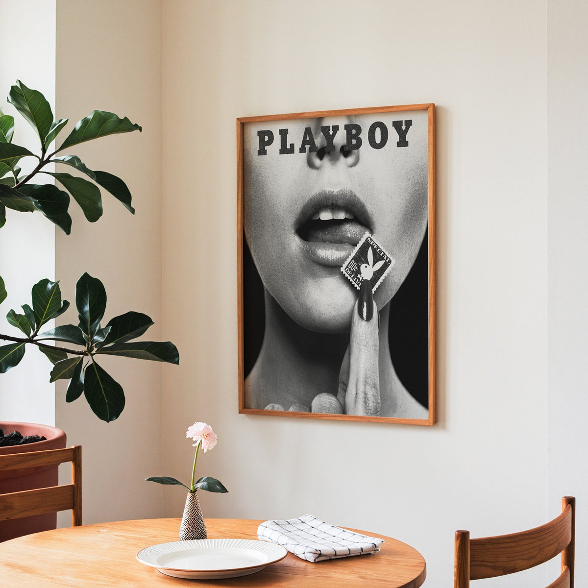 Glossy lips with postage stamp on black print in a teak frame above a round wooden dining table