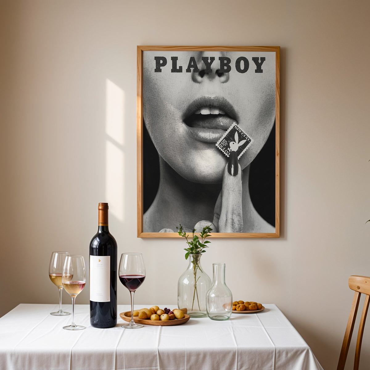 Glossy lips with postage stamp on black print in an oak frame above a table set with red wine and glasses