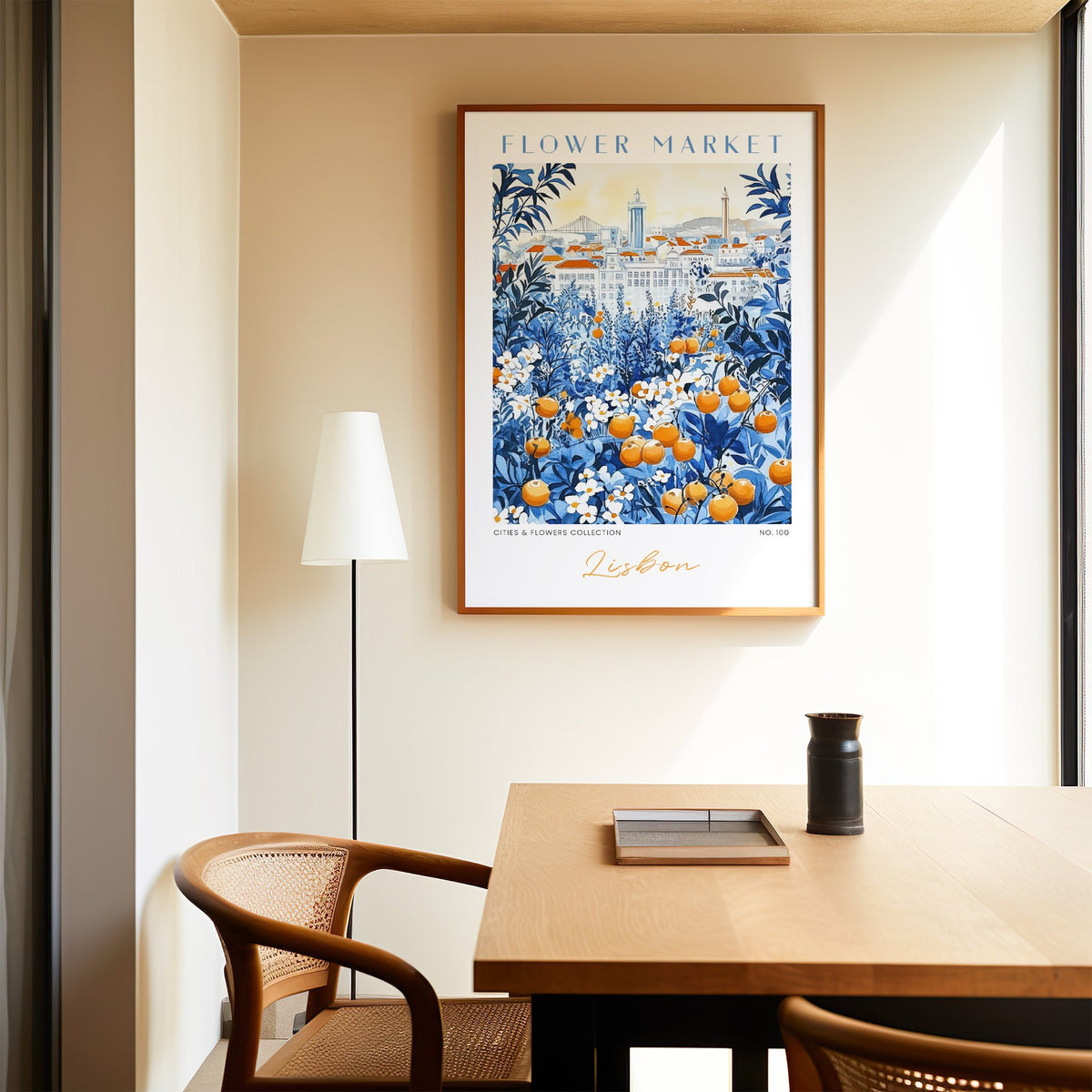 Lisbon flower market print in an oak frame above a dining table and cane chair