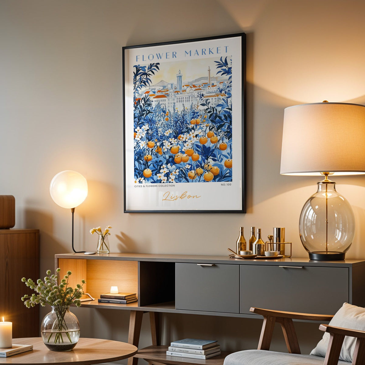 Lisbon flower market print in a black frame above a grey media console with a glass table lamp