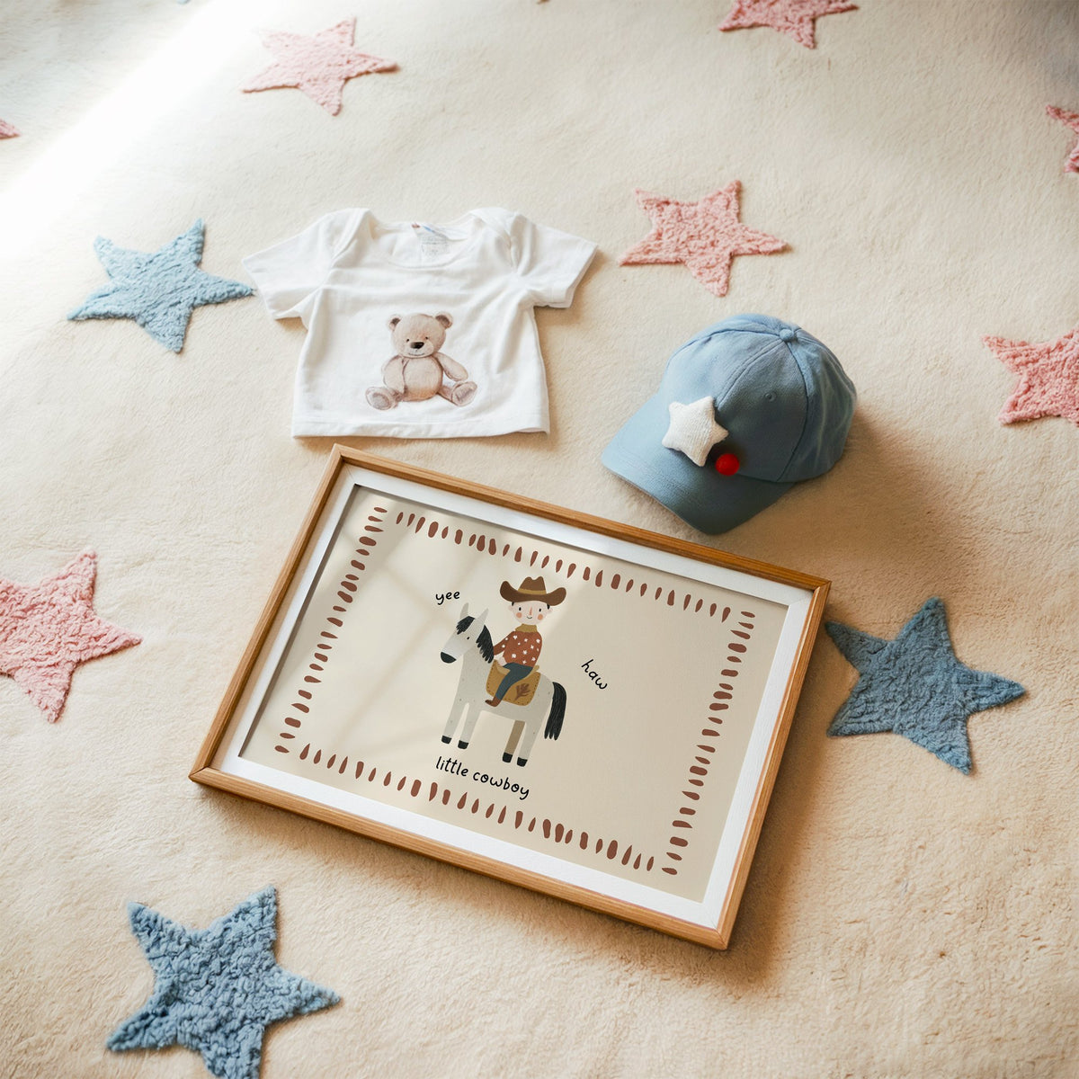 Landscape little cowboy on horse yee haw nursery print in a matted oak frame on a star rug with a baby tee