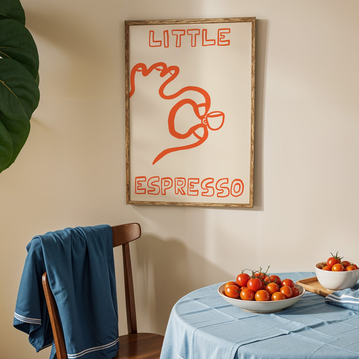 Little espresso one line print in an oak frame above a blue linen table with ripe tomatoes
