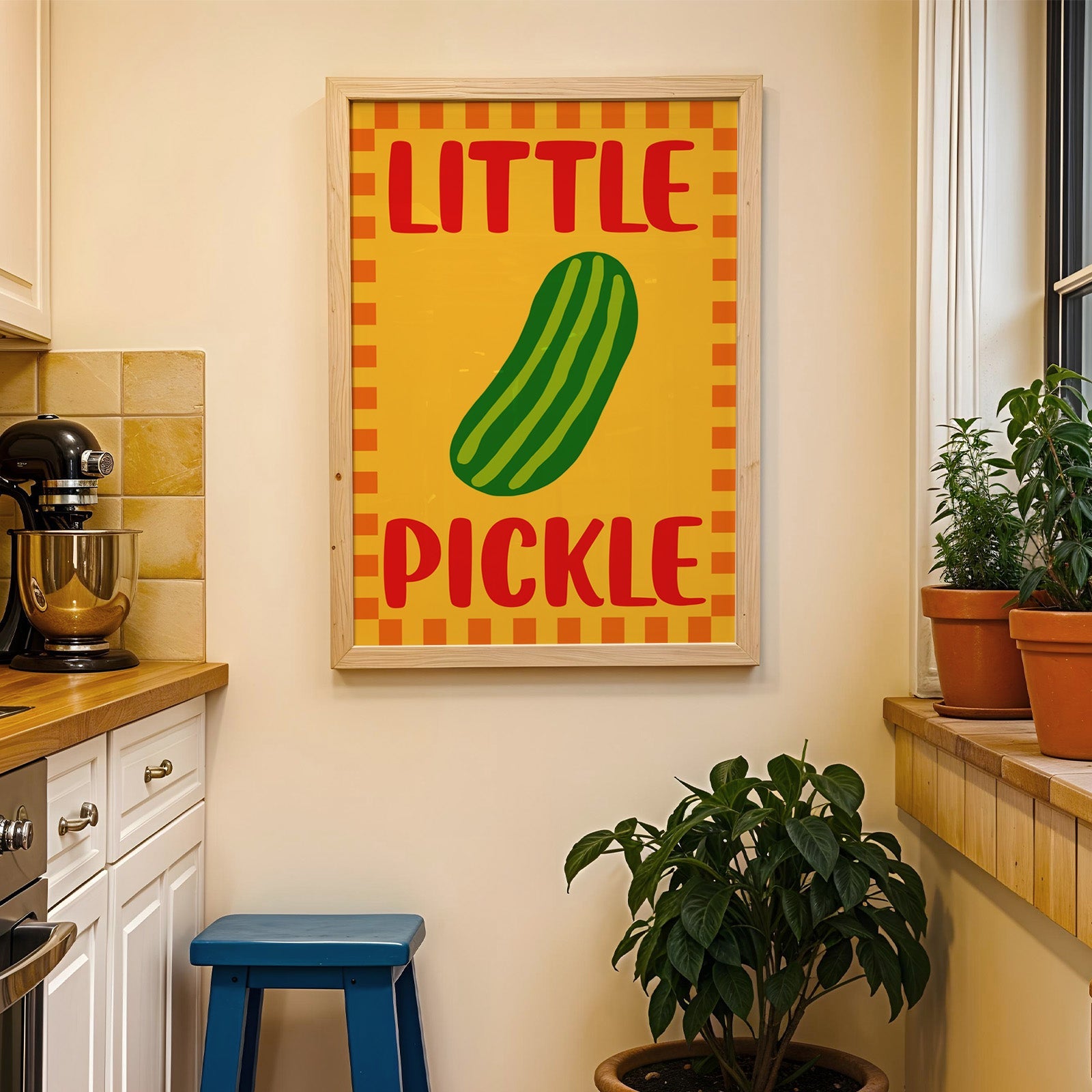 Little pickle print in a wood frame on a yellow tiled kitchen wall