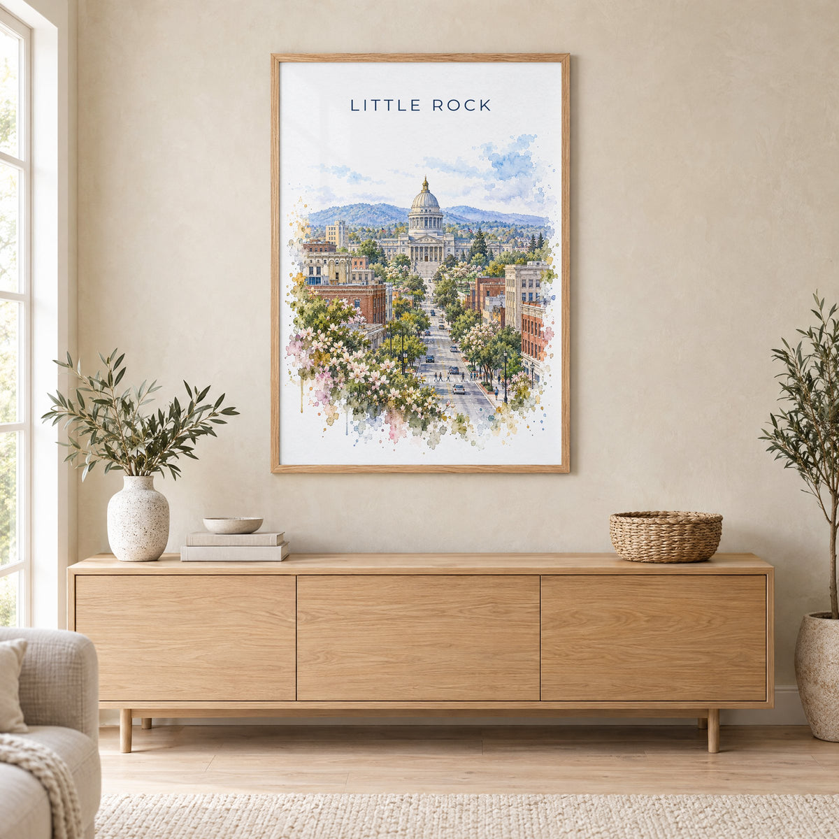 Little Rock watercolor print in an oak frame above a light wood sideboard in a Scandinavian living room