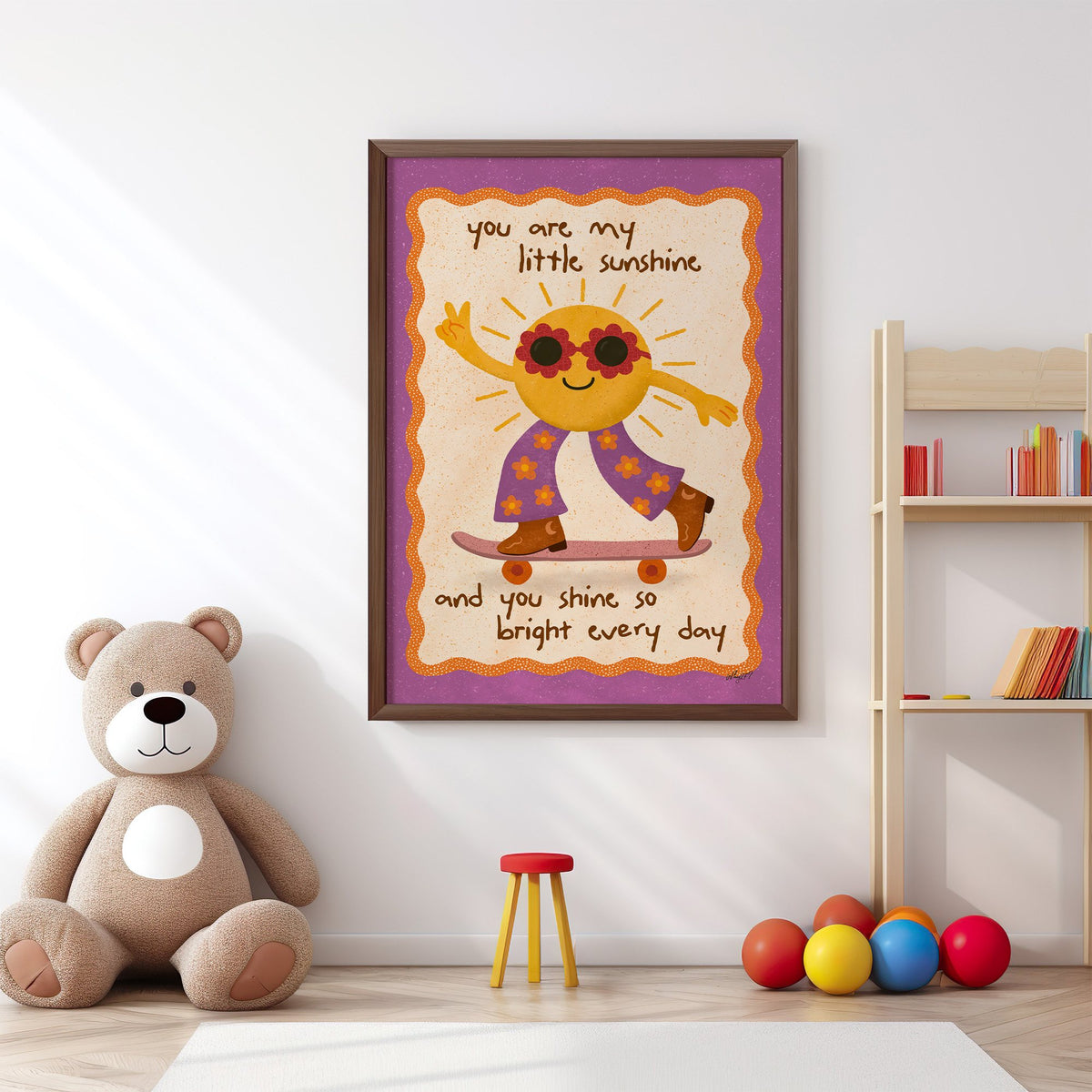 Skateboarding sun little sunshine nursery print in a walnut frame above a big teddy bear by a bookshelf