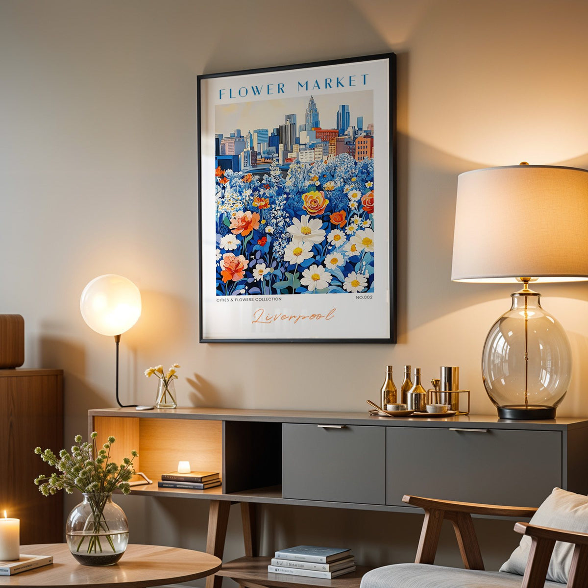 Liverpool flower market print in a black frame above a grey media console with a glass table lamp