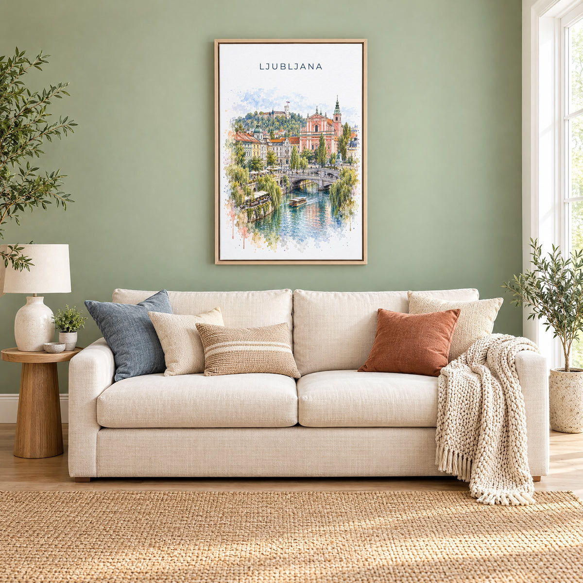 Ljubljana watercolor print as a natural floater canvas above a cream linen sofa on a sage green wall
