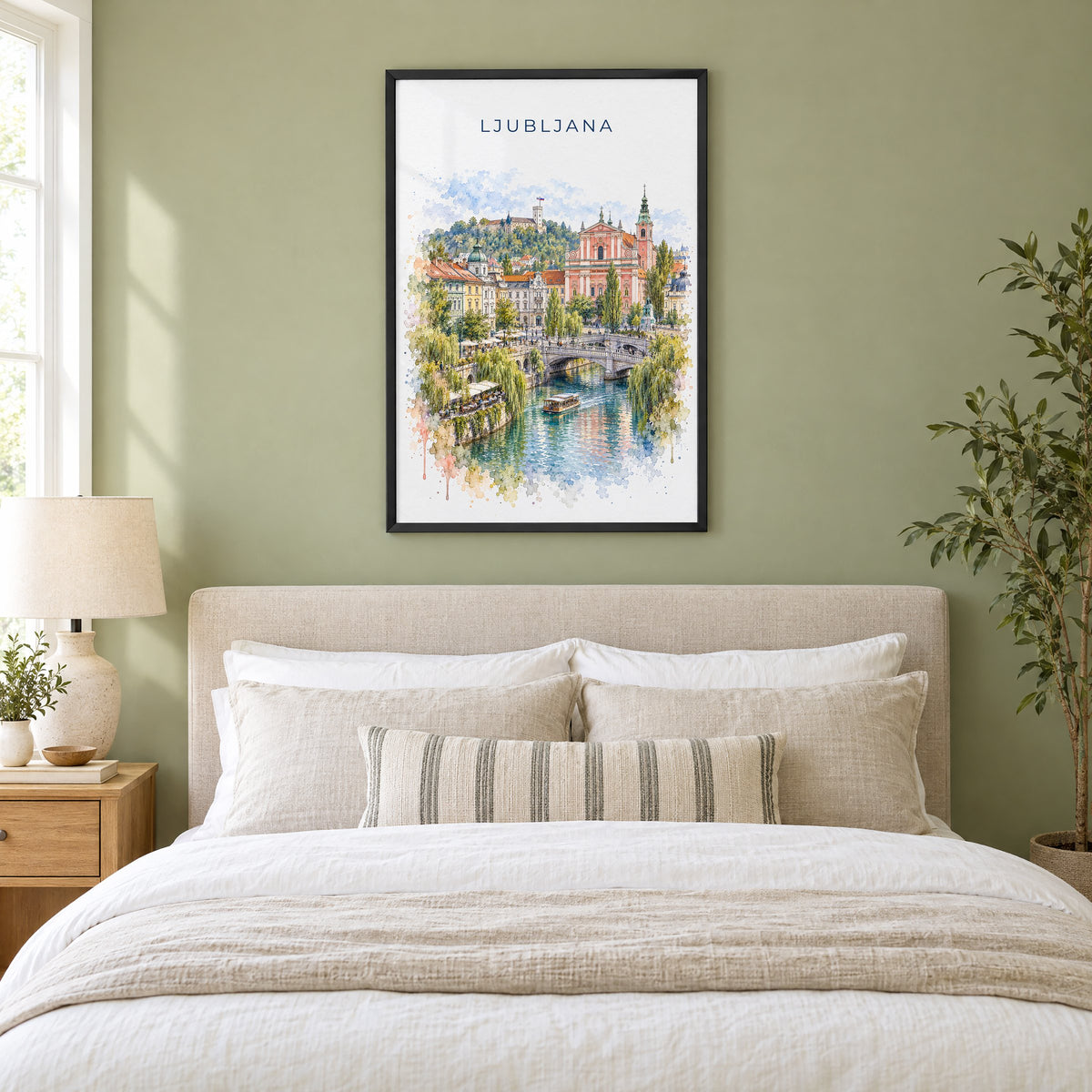 Ljubljana watercolor print in a black frame above an upholstered headboard in a sage green bedroom