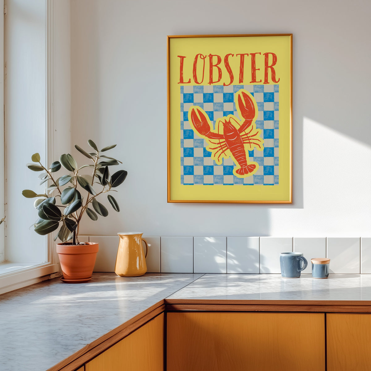 Lobster blue check print shown in a gold frame above a marble counter in a tan kitchen