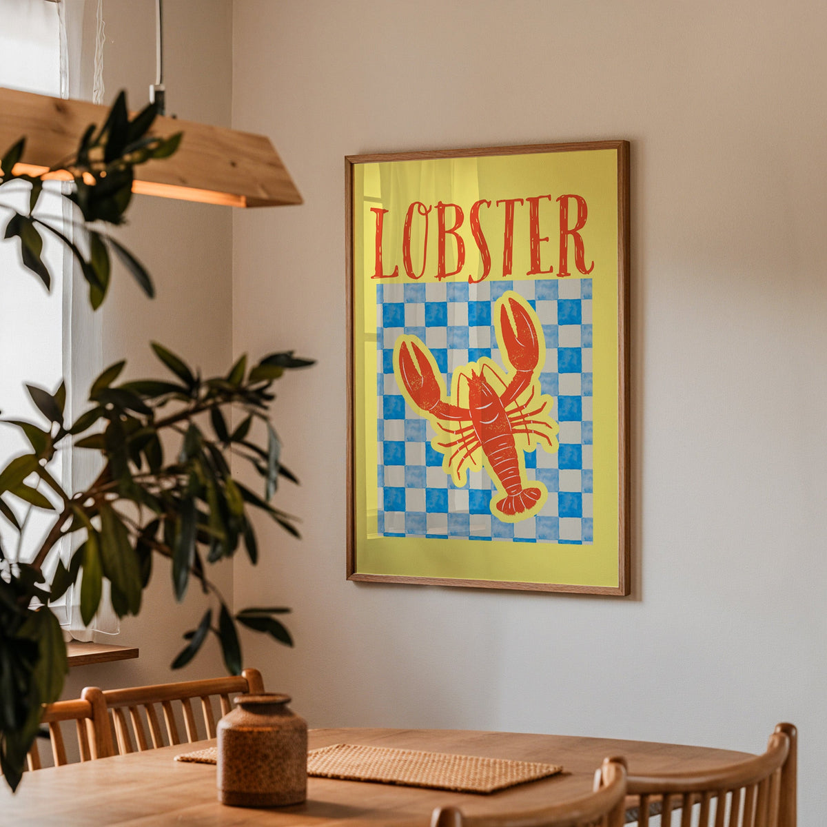 Lobster blue check print in a walnut frame above a dining table with olive branches