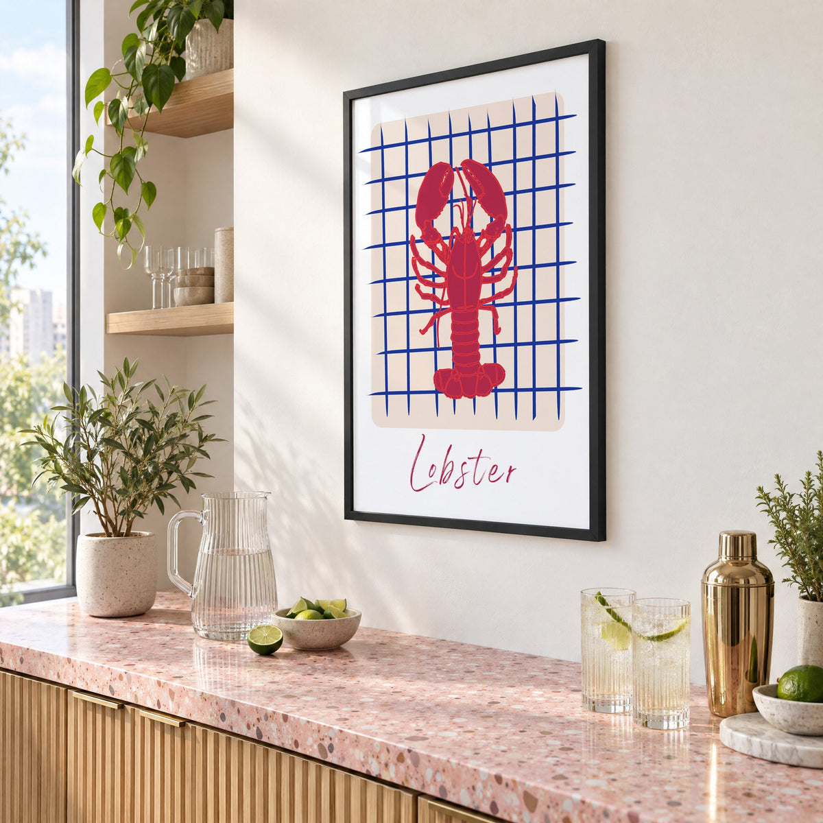 Lobster on cobalt grid print in a black frame above a pink terrazzo cocktail counter with limes, seen at an angle