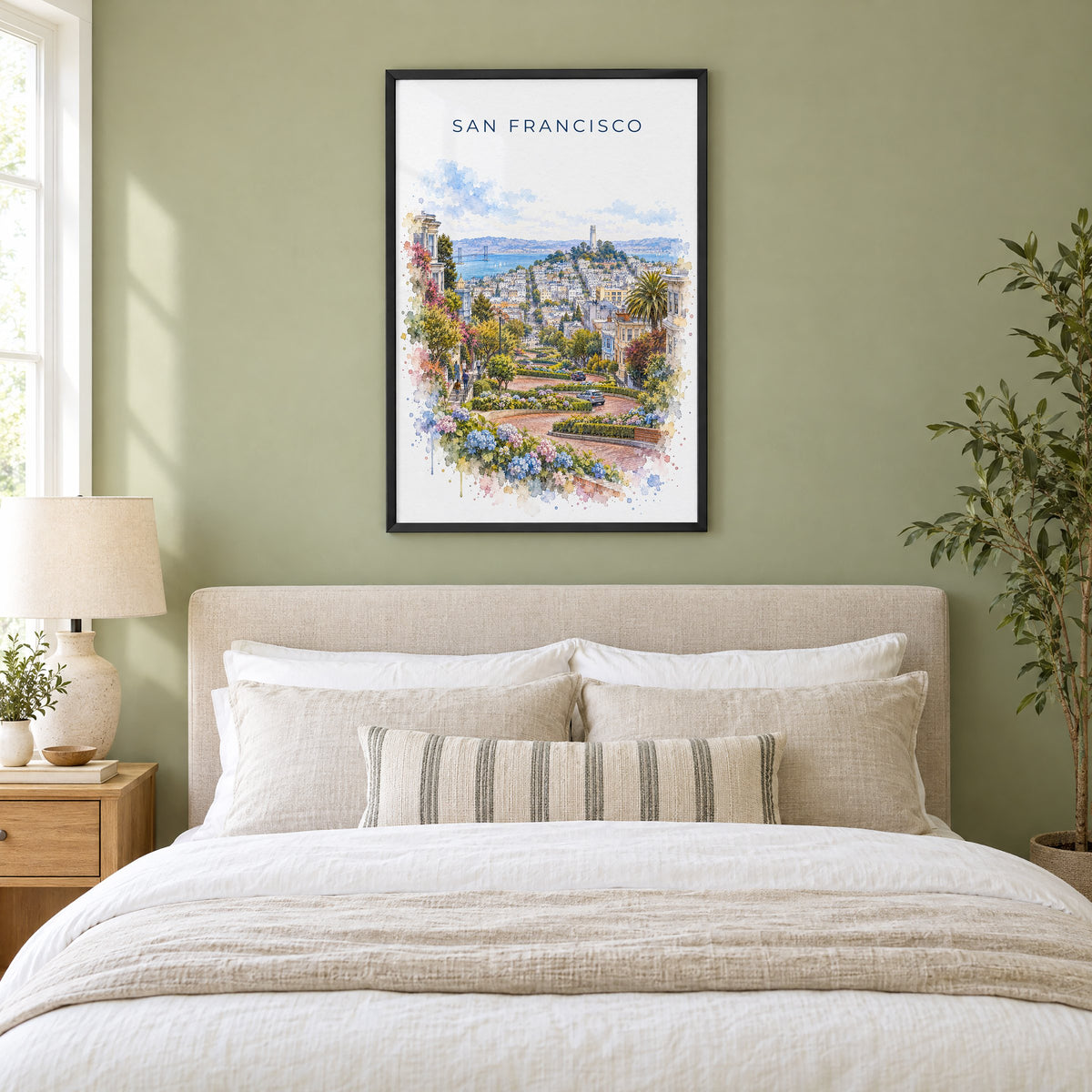Lombard Street San Francisco watercolor print in a black frame above an upholstered headboard in a sage green bedroom