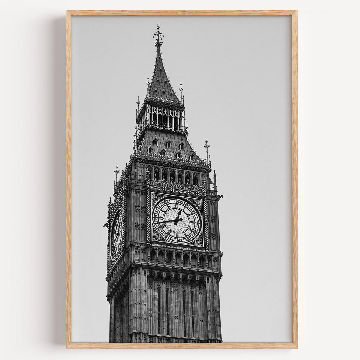 Big Ben clock tower low-angle photo print in a light oak frame on a plain white wall