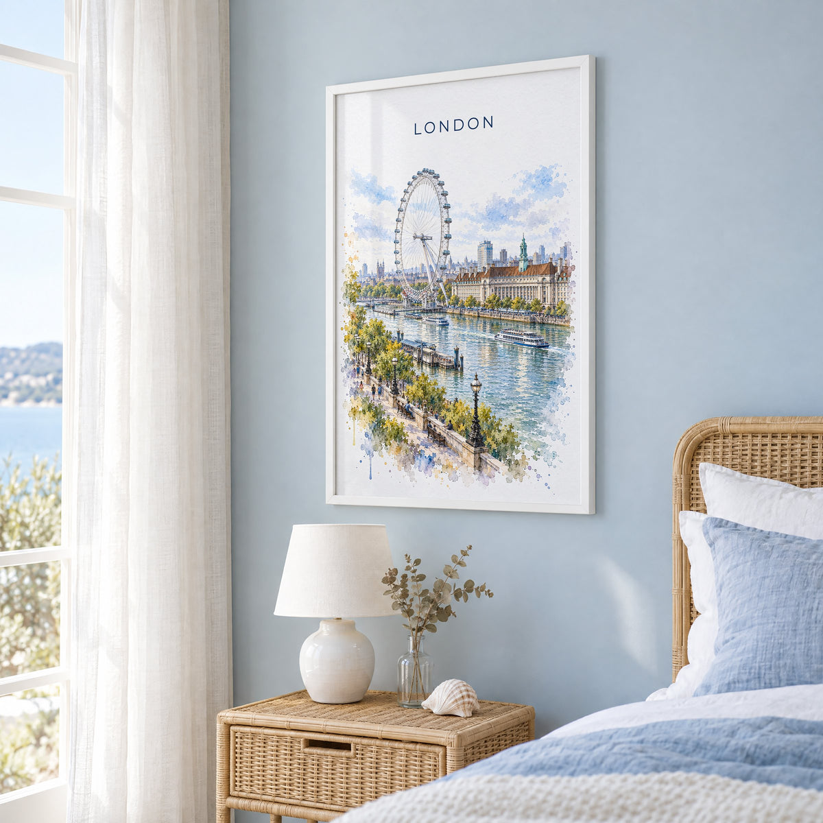 London Eye watercolor print in a white frame on a pale blue wall beside a rattan bed in a coastal bedroom