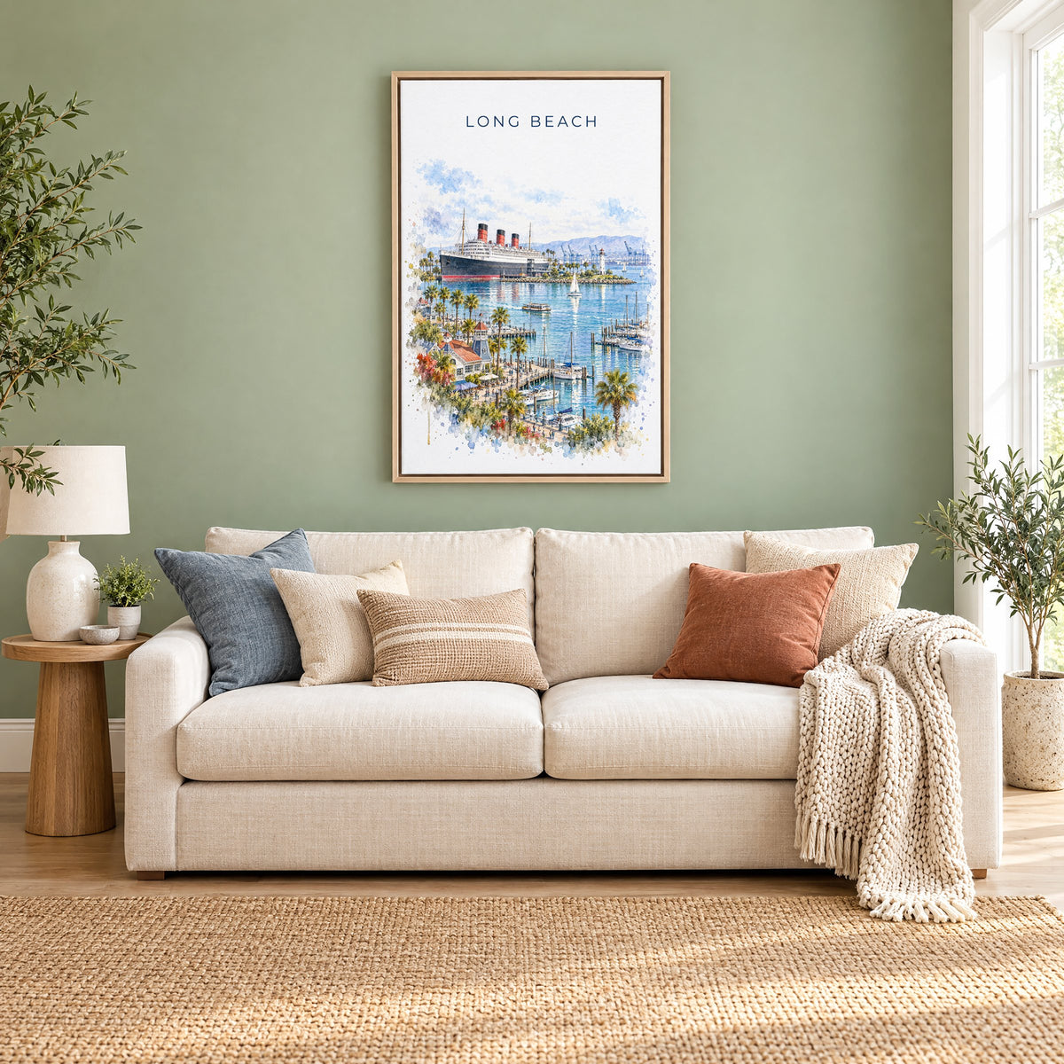 Long Beach watercolor print as a natural floater canvas above a cream linen sofa on a sage green wall