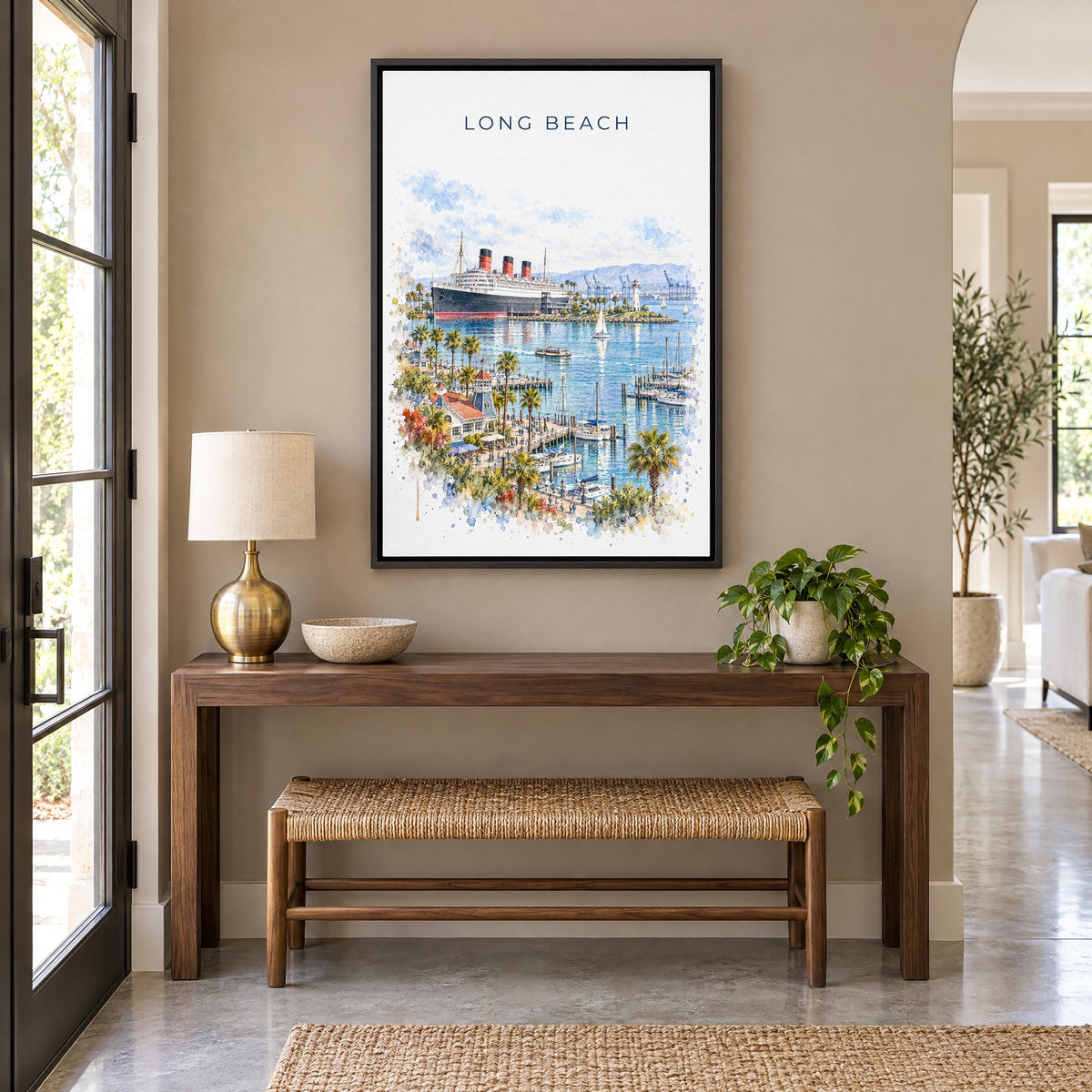 Long Beach watercolor print as a black floater canvas above a walnut console and woven bench in an entryway