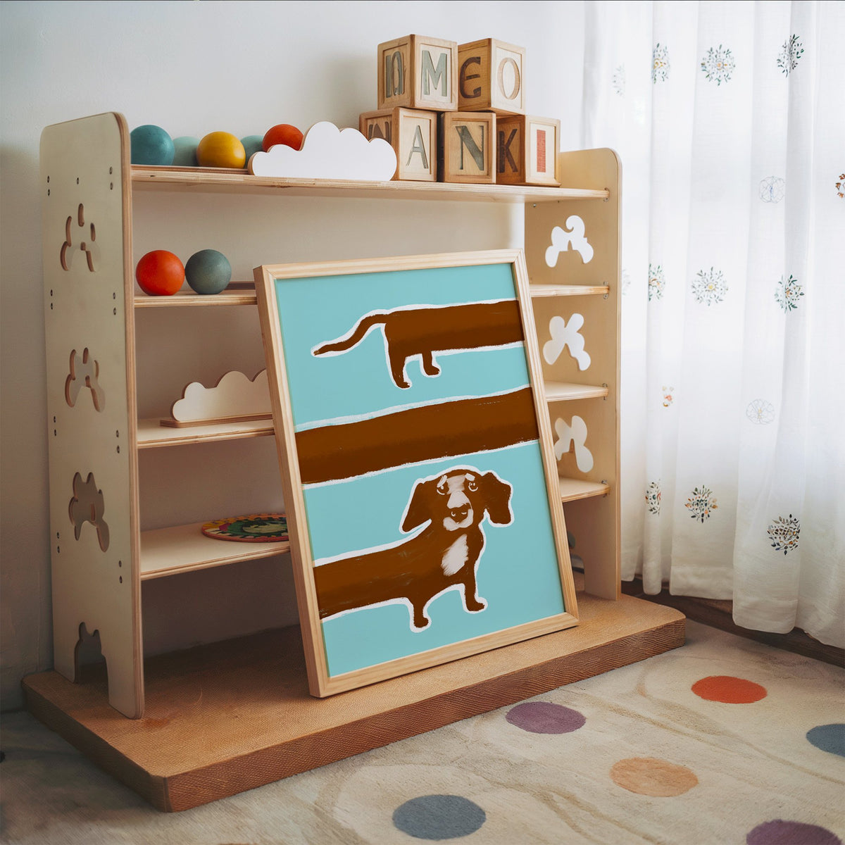 Extra long dachshund in three rows nursery print in an oak frame leaning on a toy shelf with wooden letter blocks